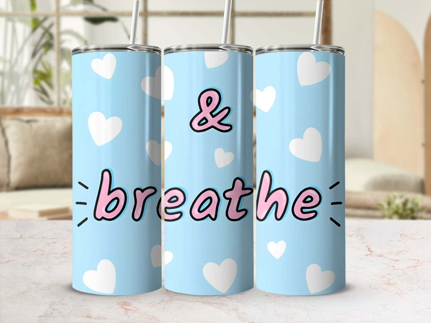 Light blue tumbler with white hearts and "& breathe" text.