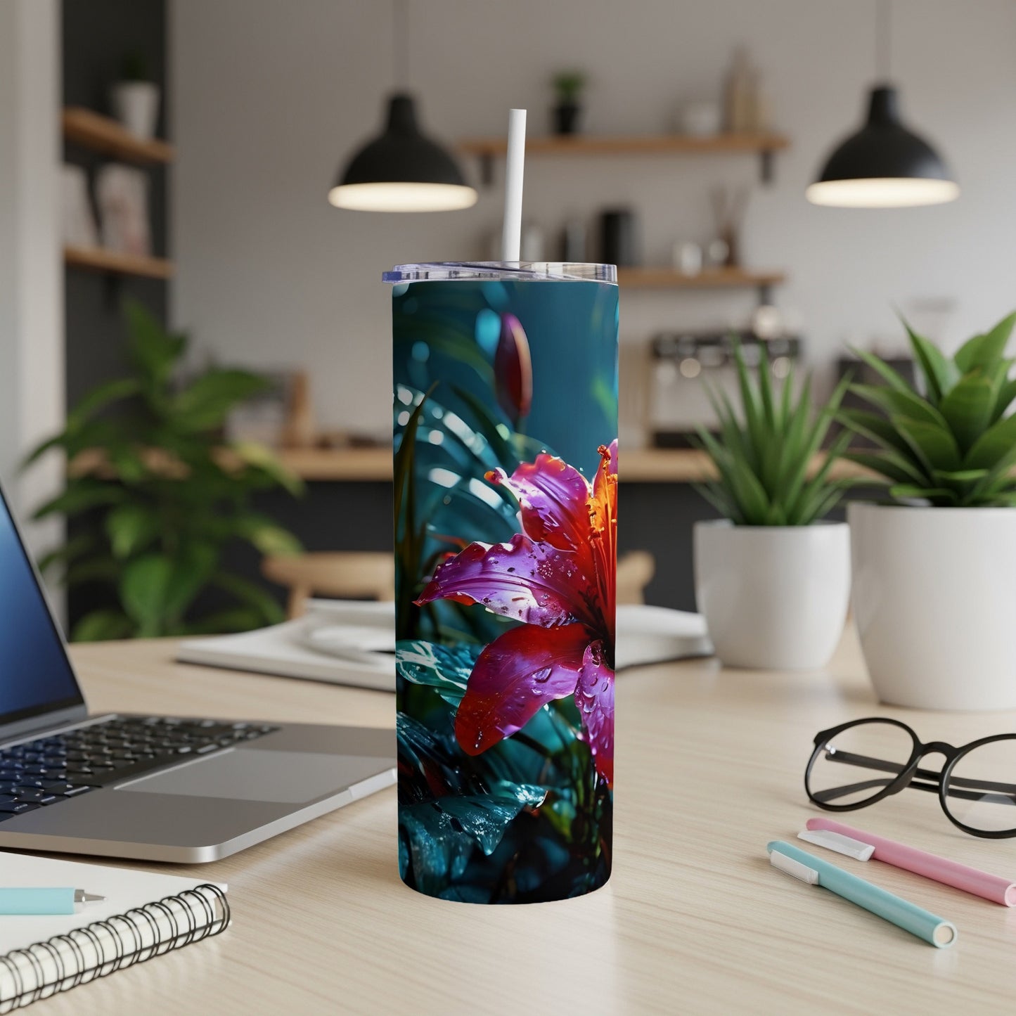 Red lily with water droplets on a stainless steel tumbler.