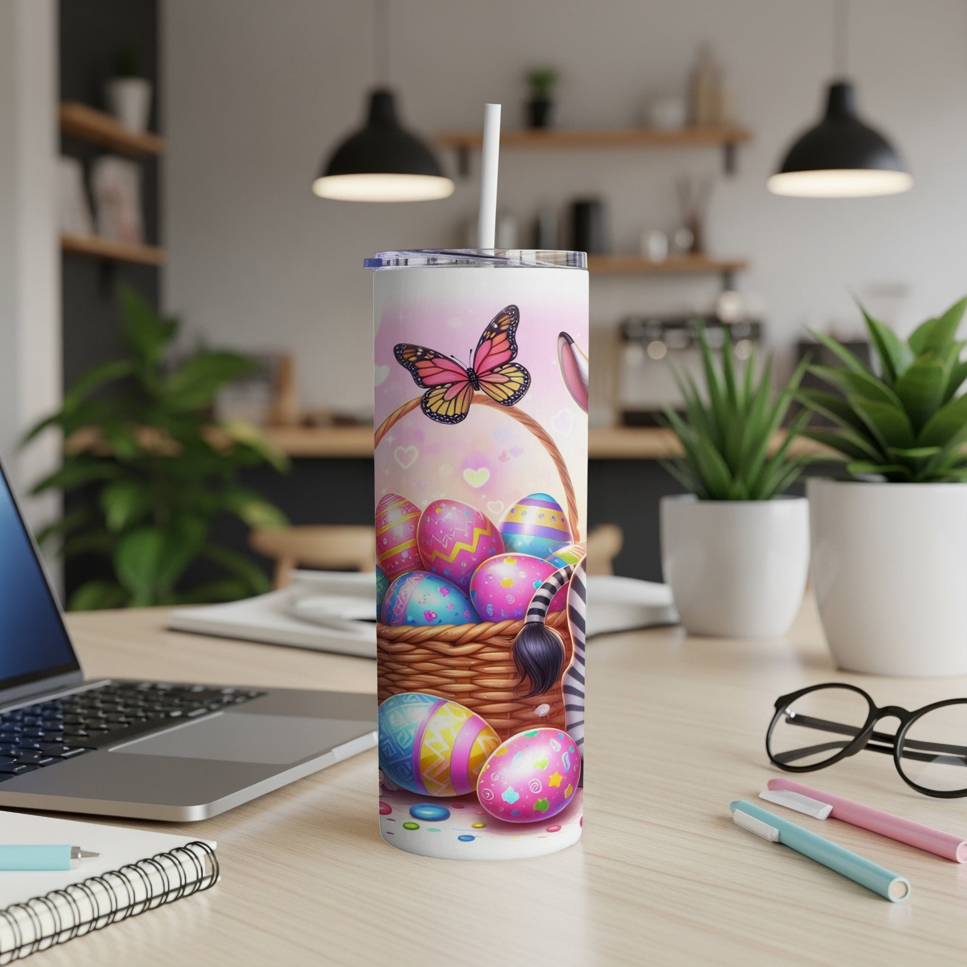 Easter basket with decorated eggs and straw on a desk with a laptop.