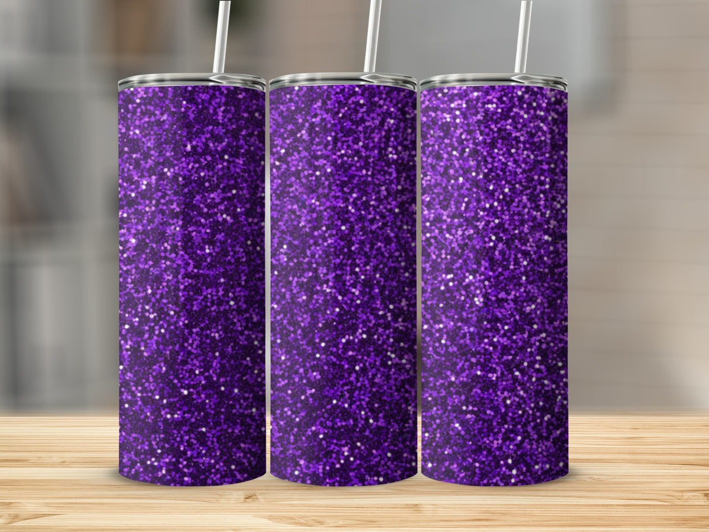 Three purple glitter tumblers with straws displayed on a wooden surface.