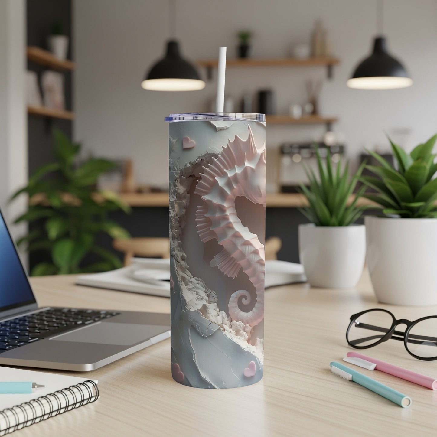 Pale pink seahorse pattern on a white and gray tumbler with a straw.