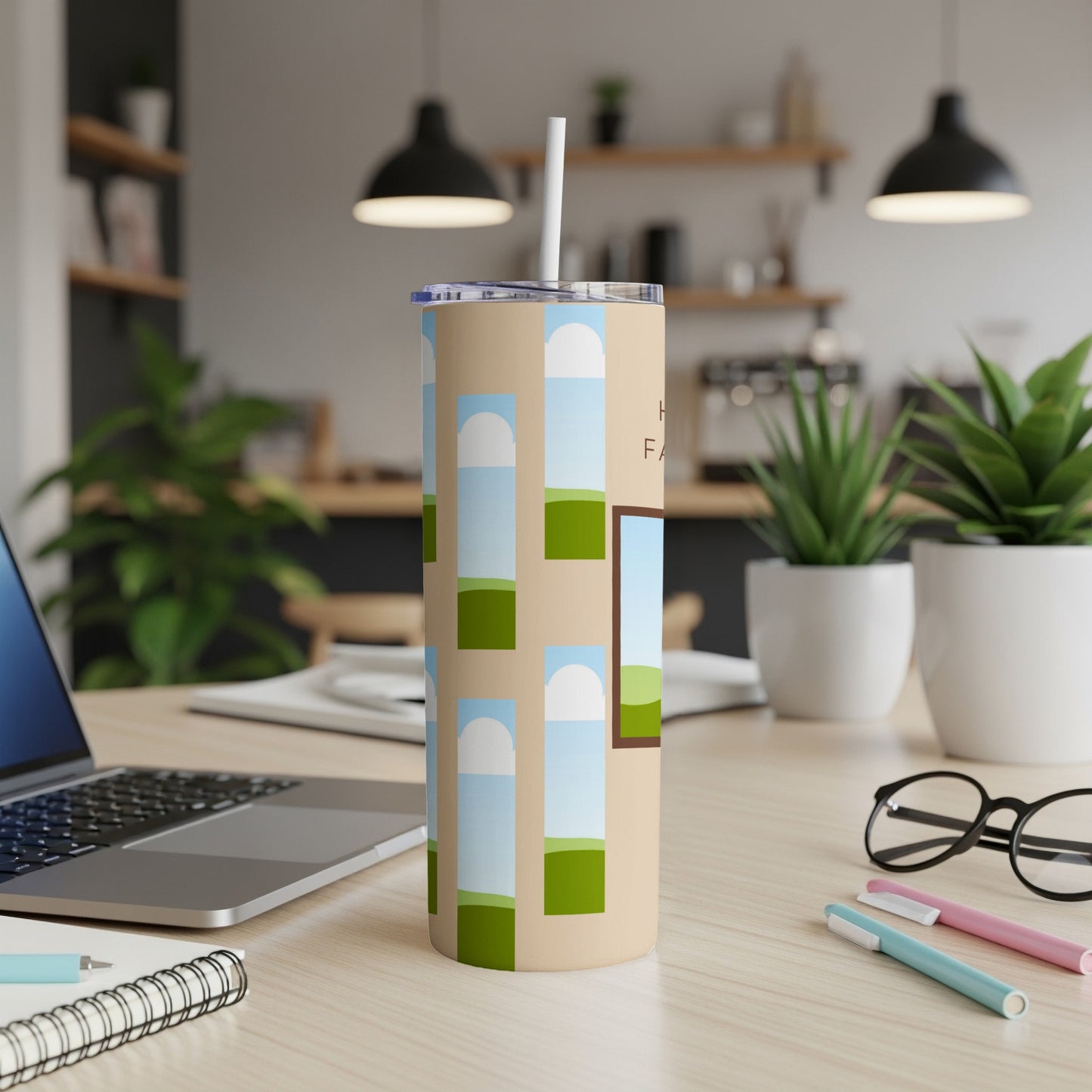Beige tumbler with a repeating blue sky and green field design and text.