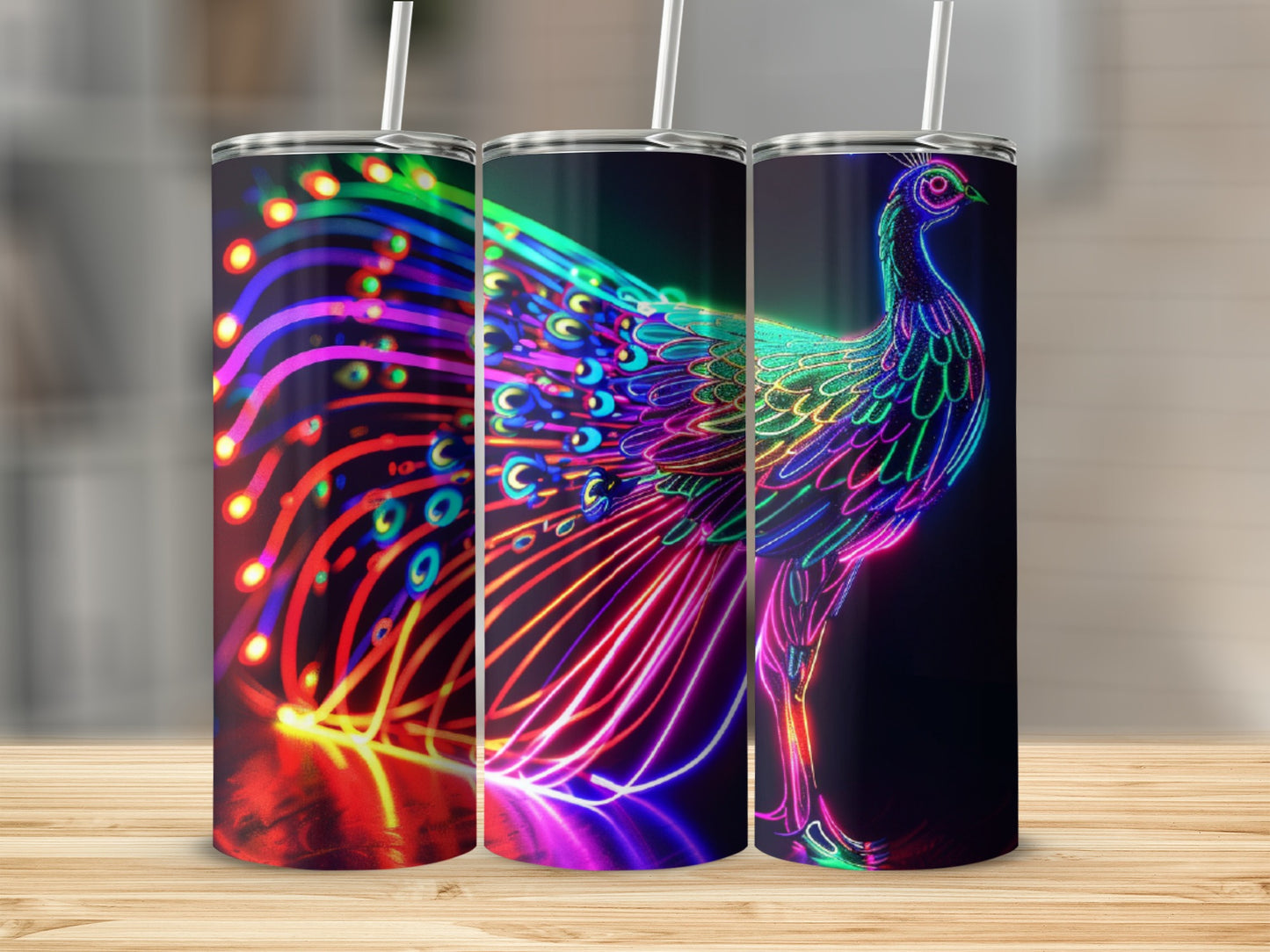 Neon peacock design on three tumblers with straws, against a blurred background.