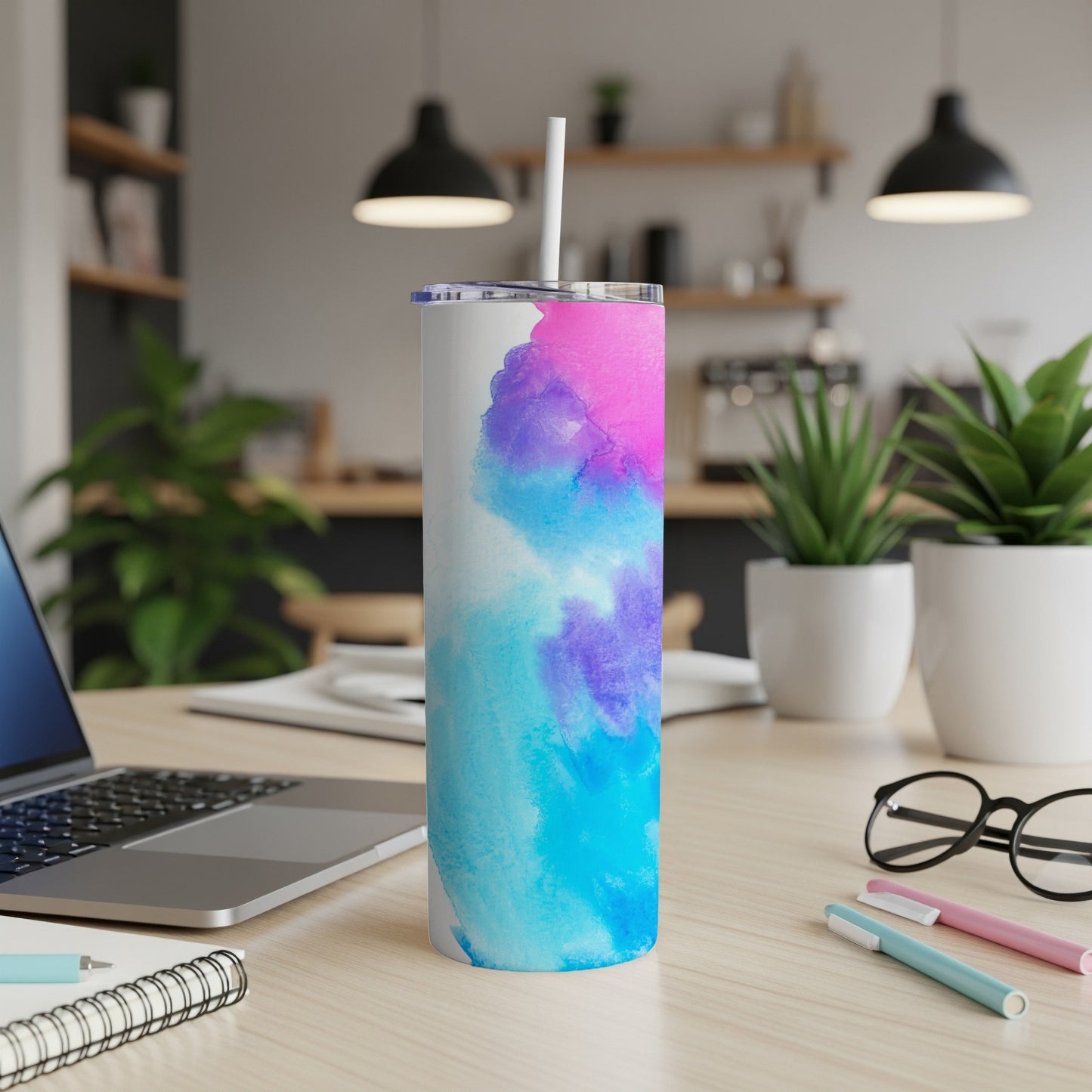 White tumbler with abstract pink and blue watercolor design and straw.