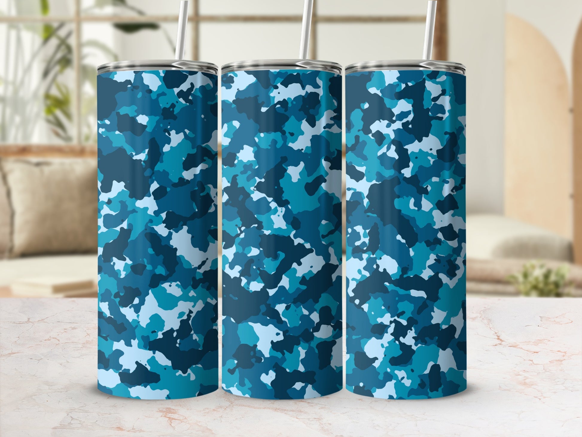 Three tumblers with blue camouflage pattern and metal straws.