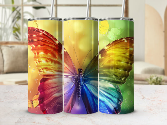 Colorful butterfly wings on three tumblers against a blurred background.