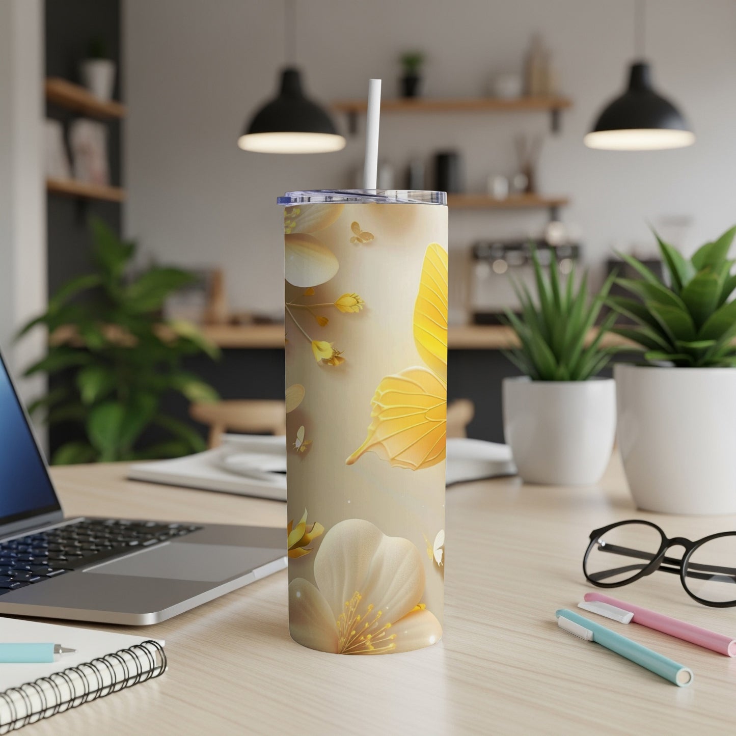 Gold butterfly and floral design on a tall, insulated tumbler with straw.