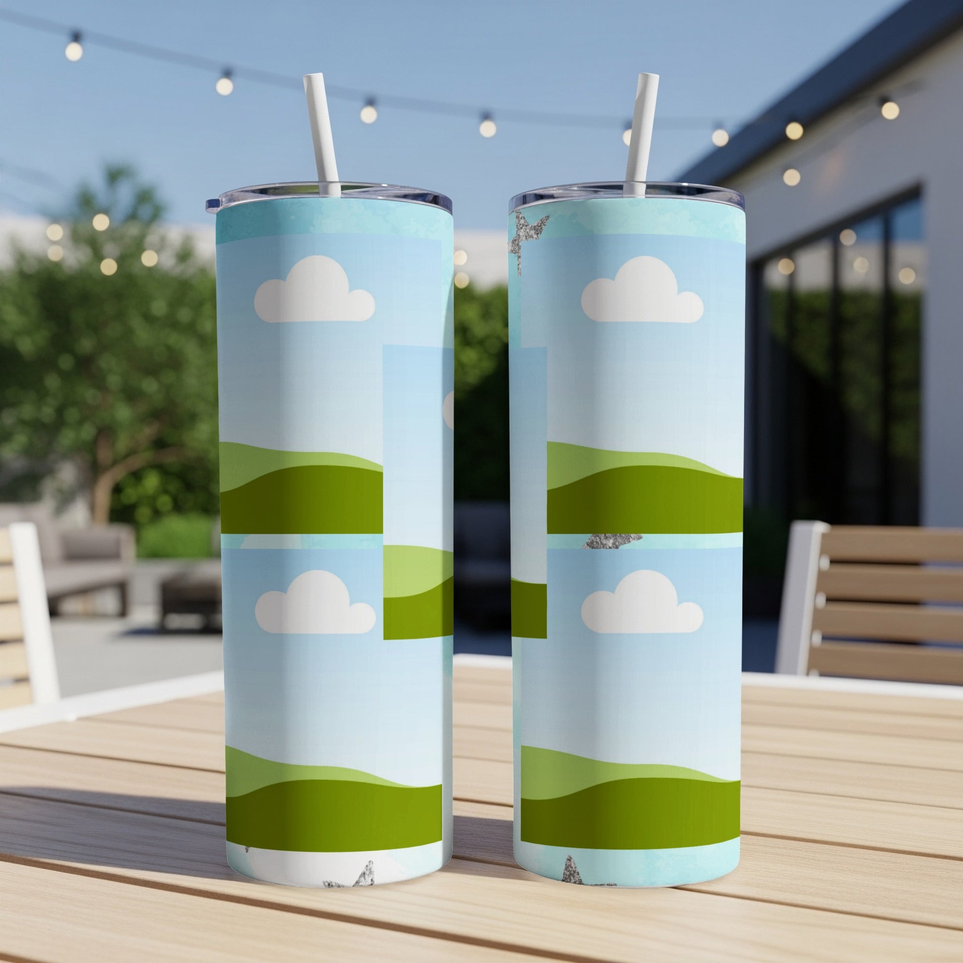 Two tumblers with a stylized landscape of rolling green hills and clouds design.