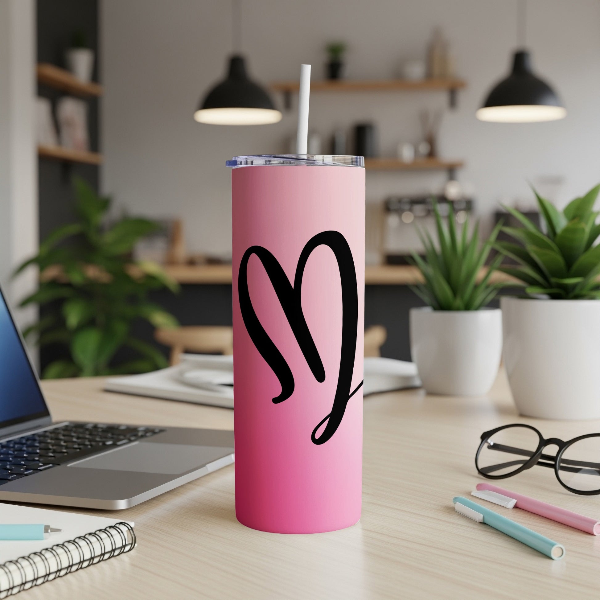 Pink tumbler with black heart graphic and white straw.