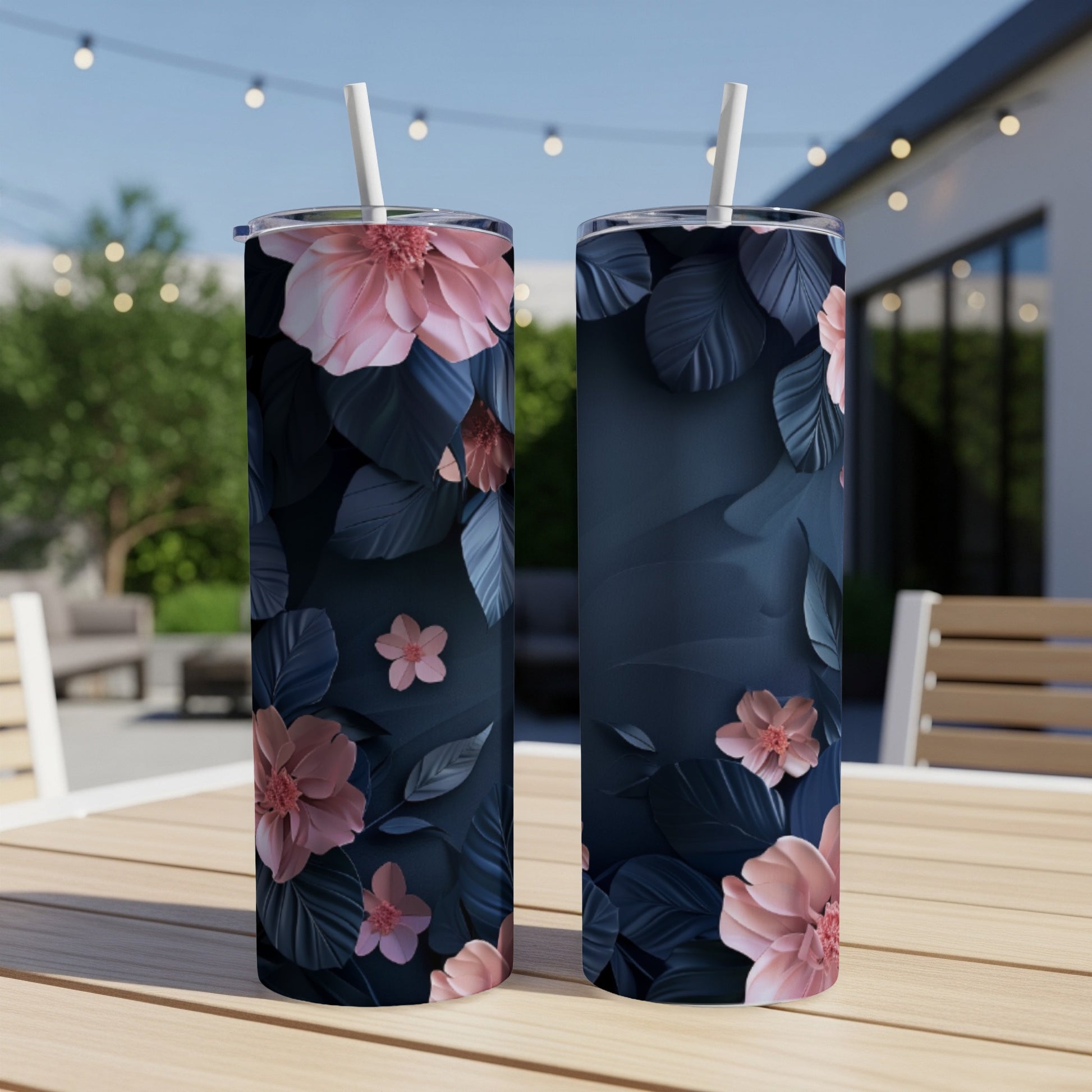 Two dark blue tumblers with pink floral patterns sit on a wooden table.