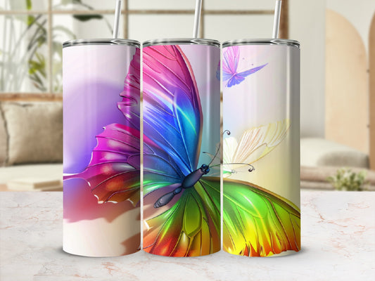 Three tumblers with colorful butterfly designs on a light, marble-like surface.