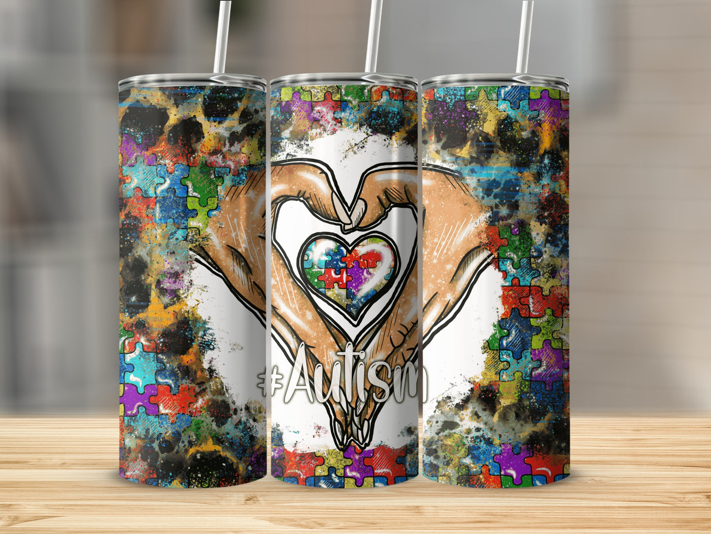 Three tumblers with a colorful puzzle heart design and "Autism" hashtag.