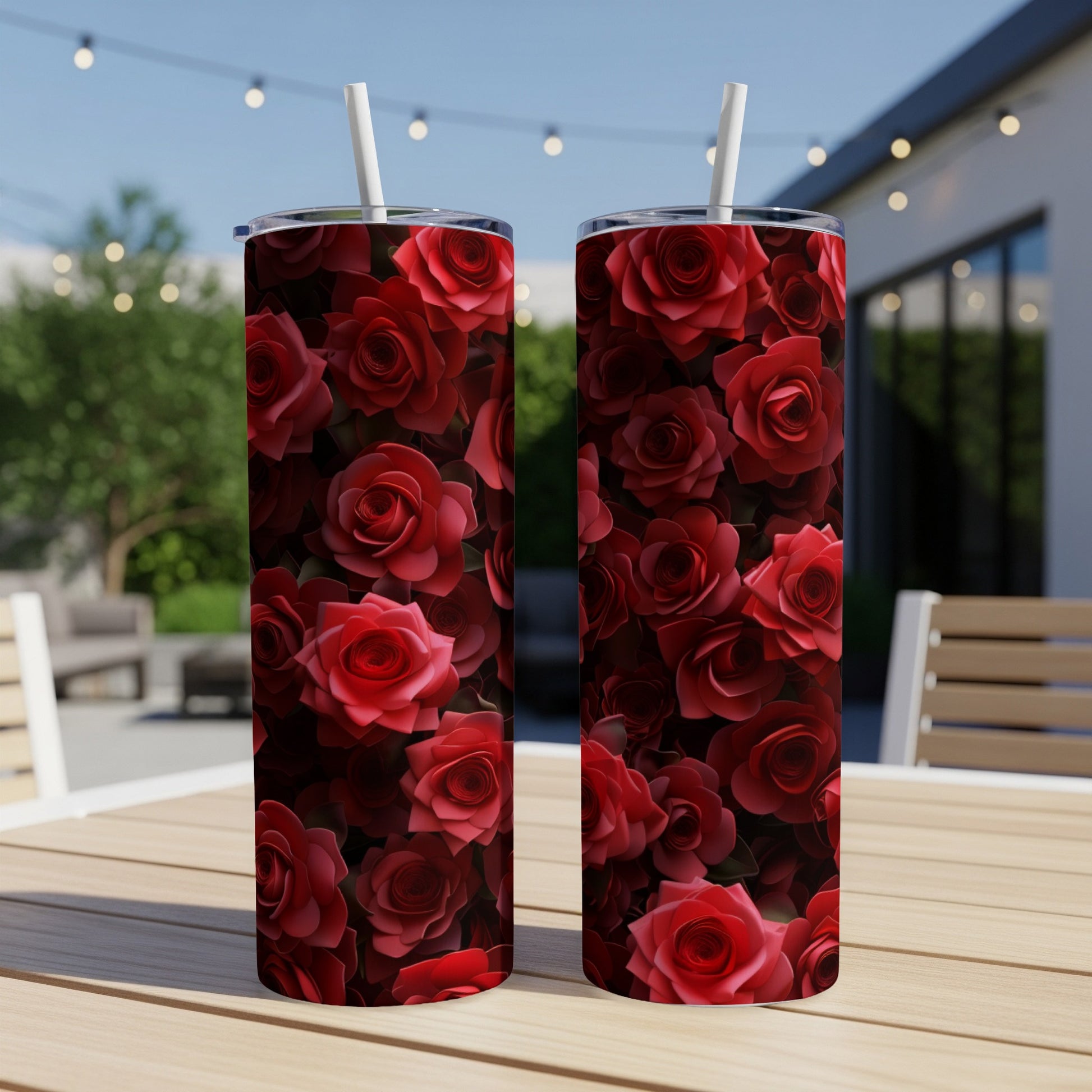 Two tumblers with a vibrant red rose pattern, standing on a table.