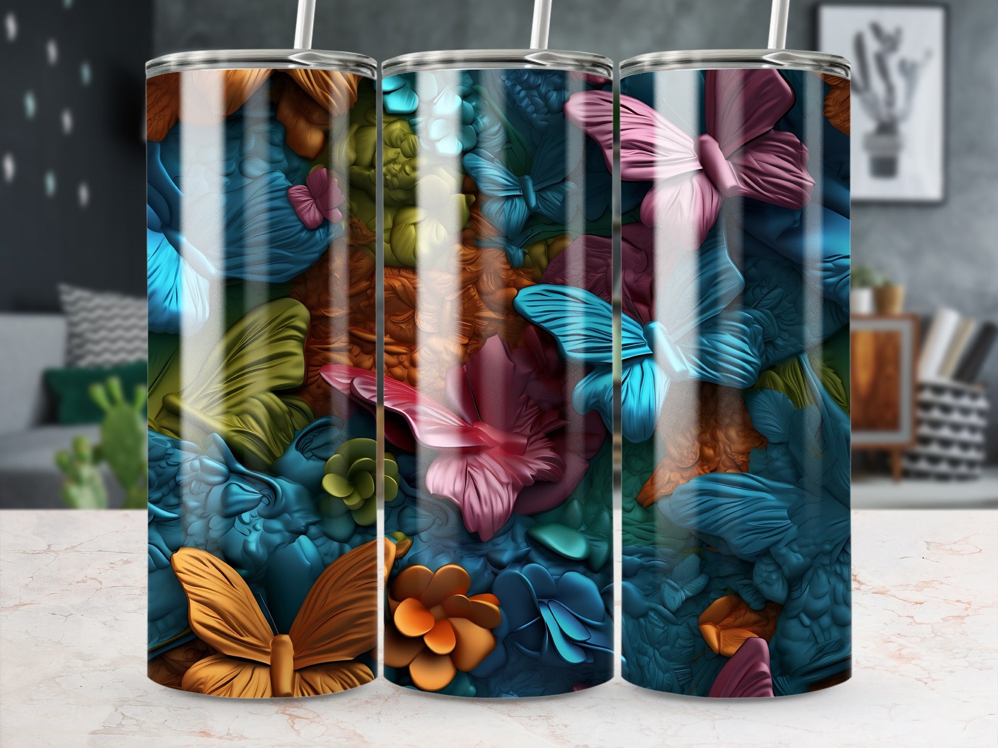 Three tumblers with colorful butterfly and floral designs displayed side-by-side.