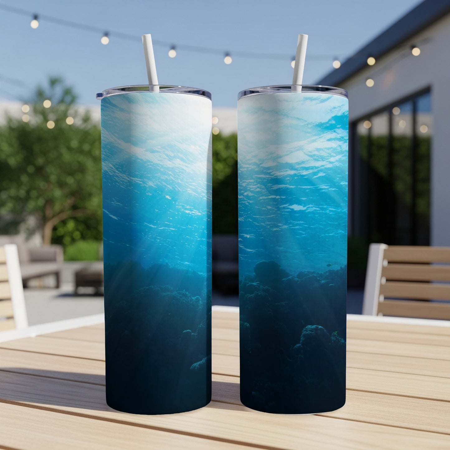 Two tumblers with underwater coral reef scene and light rays.