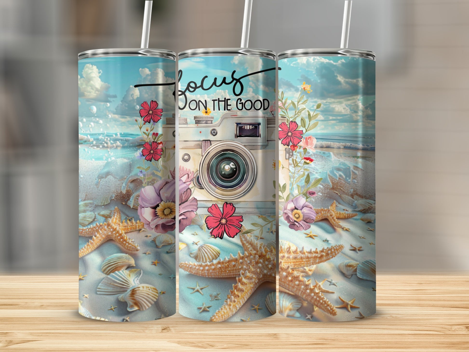 Tumbler with a beach scene, camera, and "Focus on the good" text.