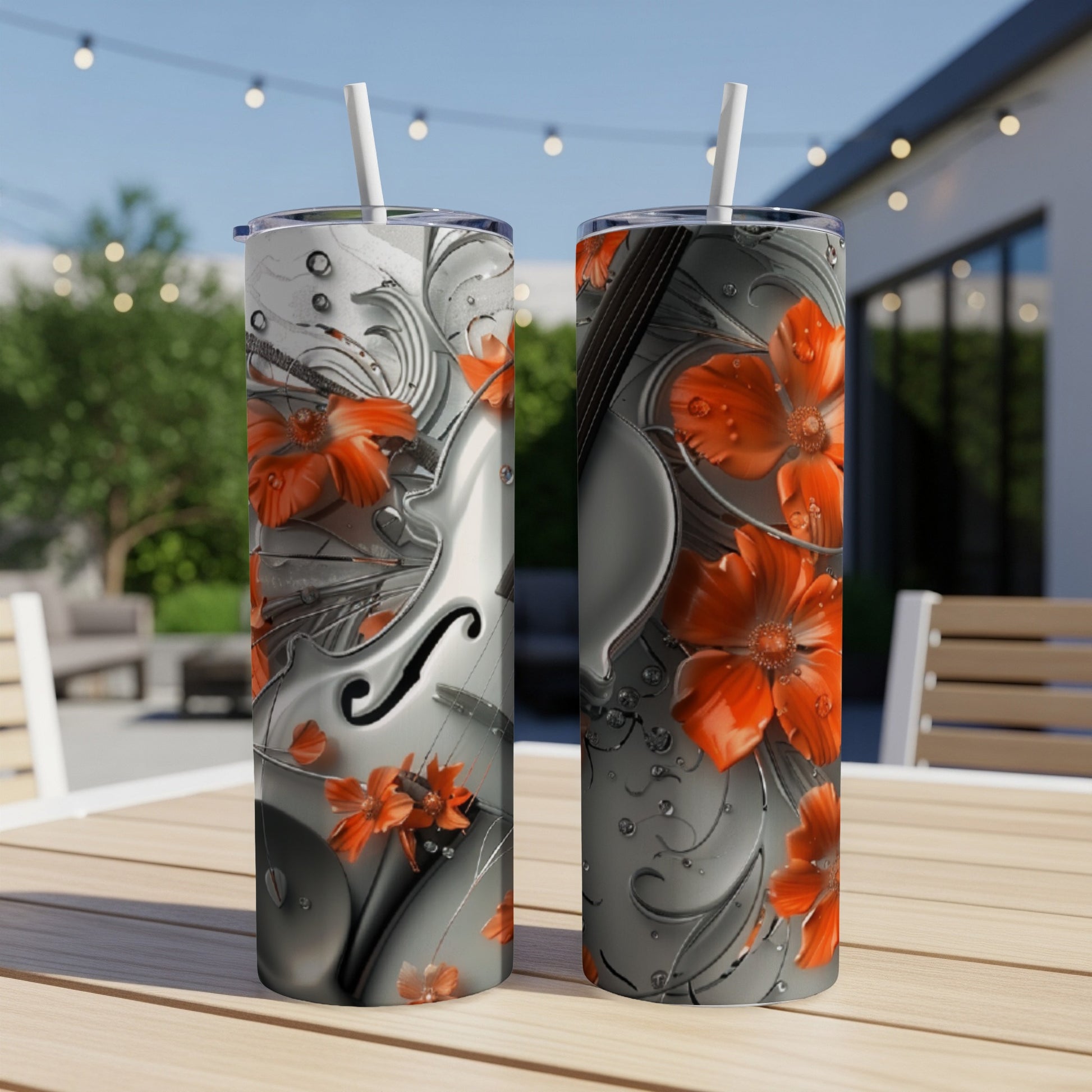 Two tumblers with floral and violin design on an outdoor table.