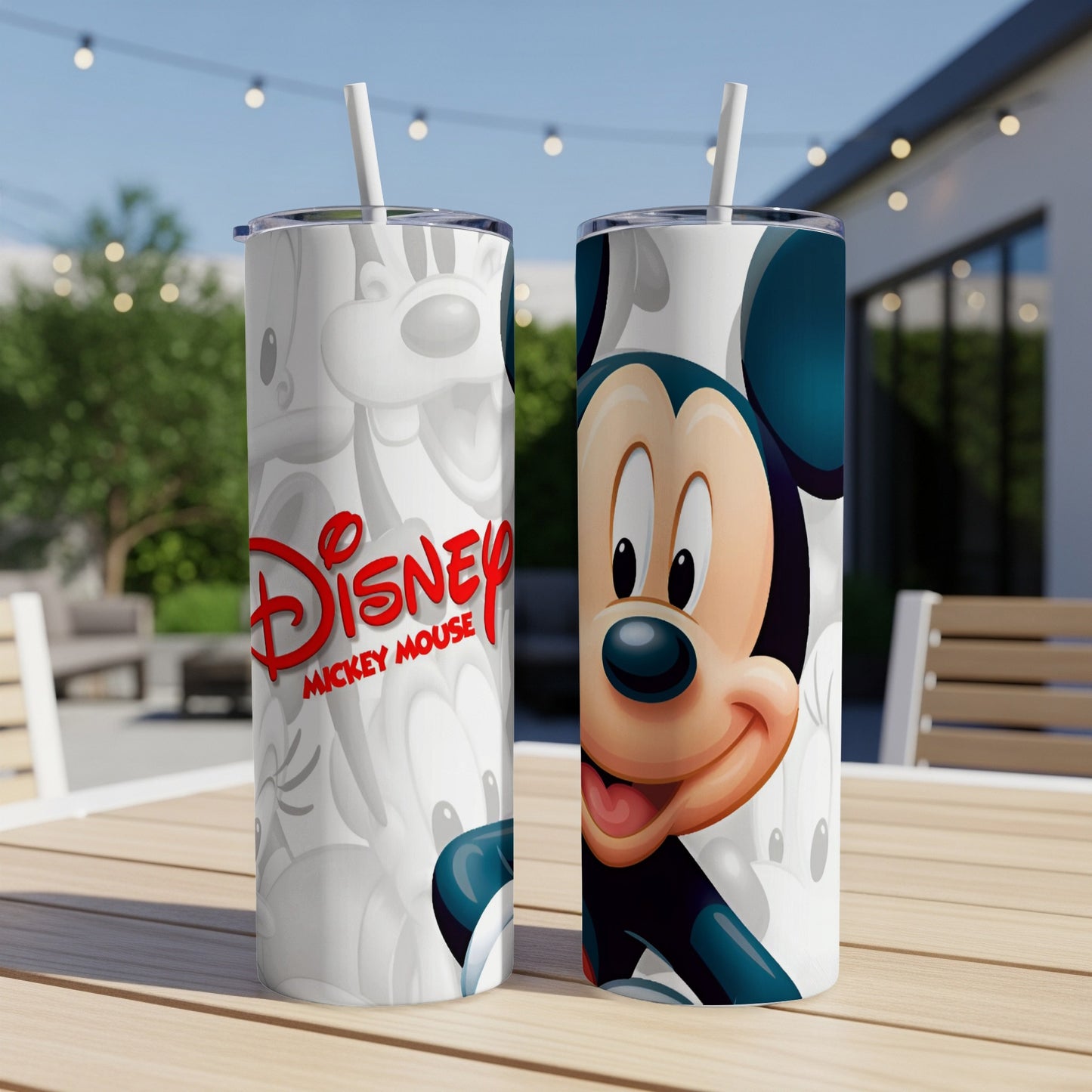 Two Disney Mickey Mouse tumblers on a table, one with a close-up of Mickey's face.
