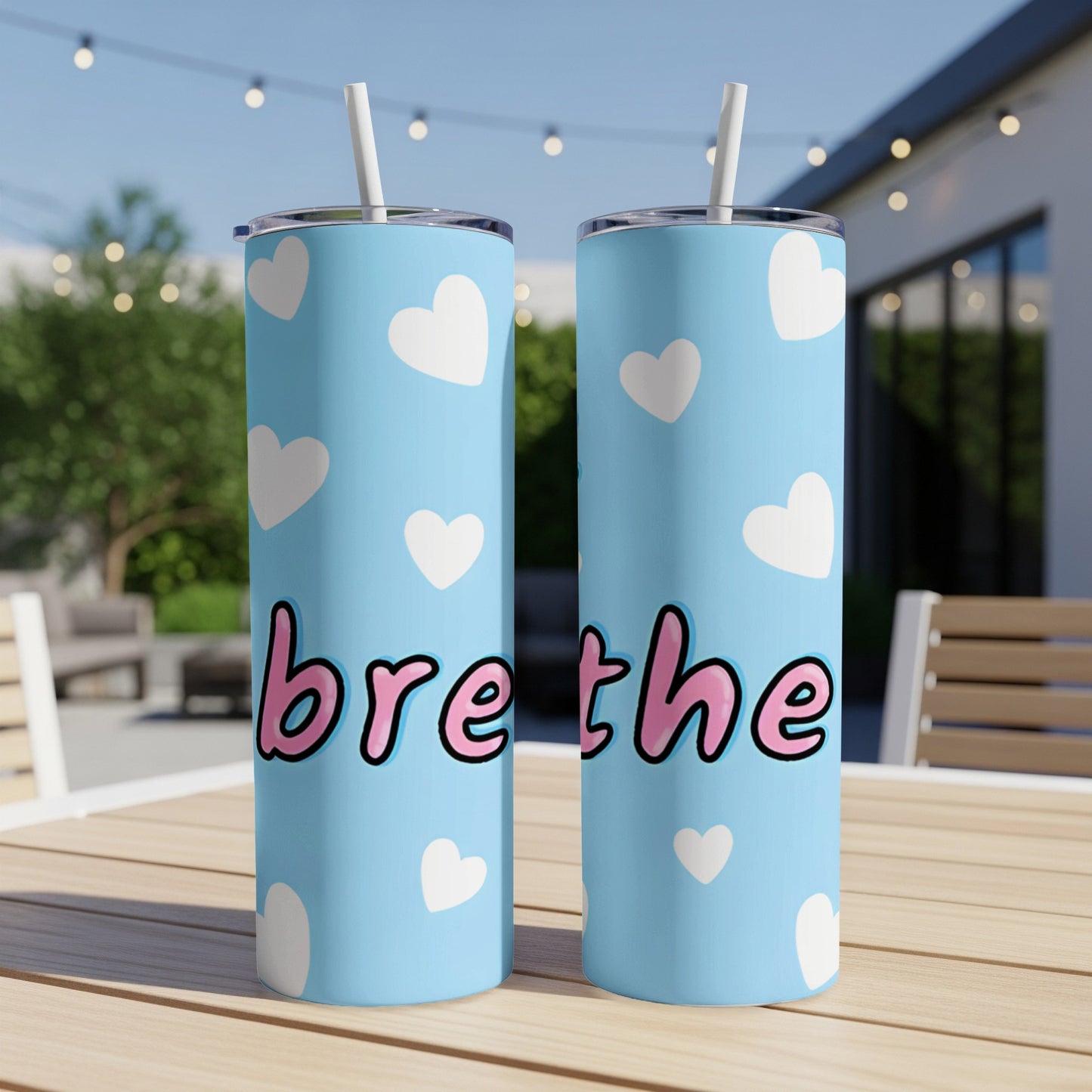 Light blue tumbler with "breathe" text and white heart pattern.