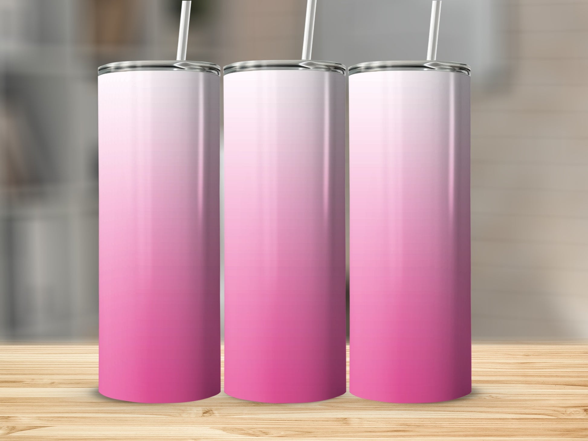 Three tall, skinny tumblers with a pink gradient design, standing on a wooden surface.