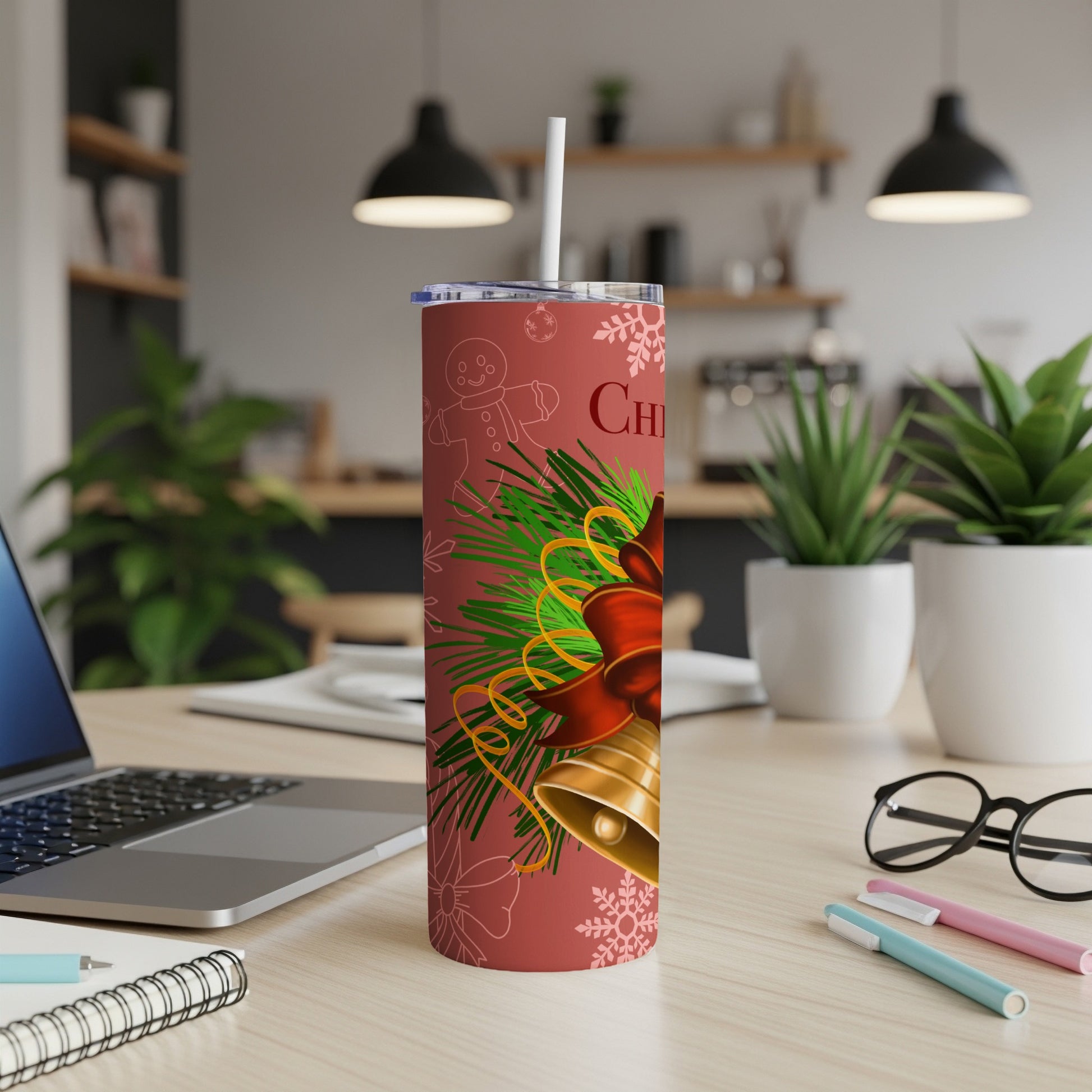 Red tumbler with Christmas bells, pine needles, and snowflakes design.