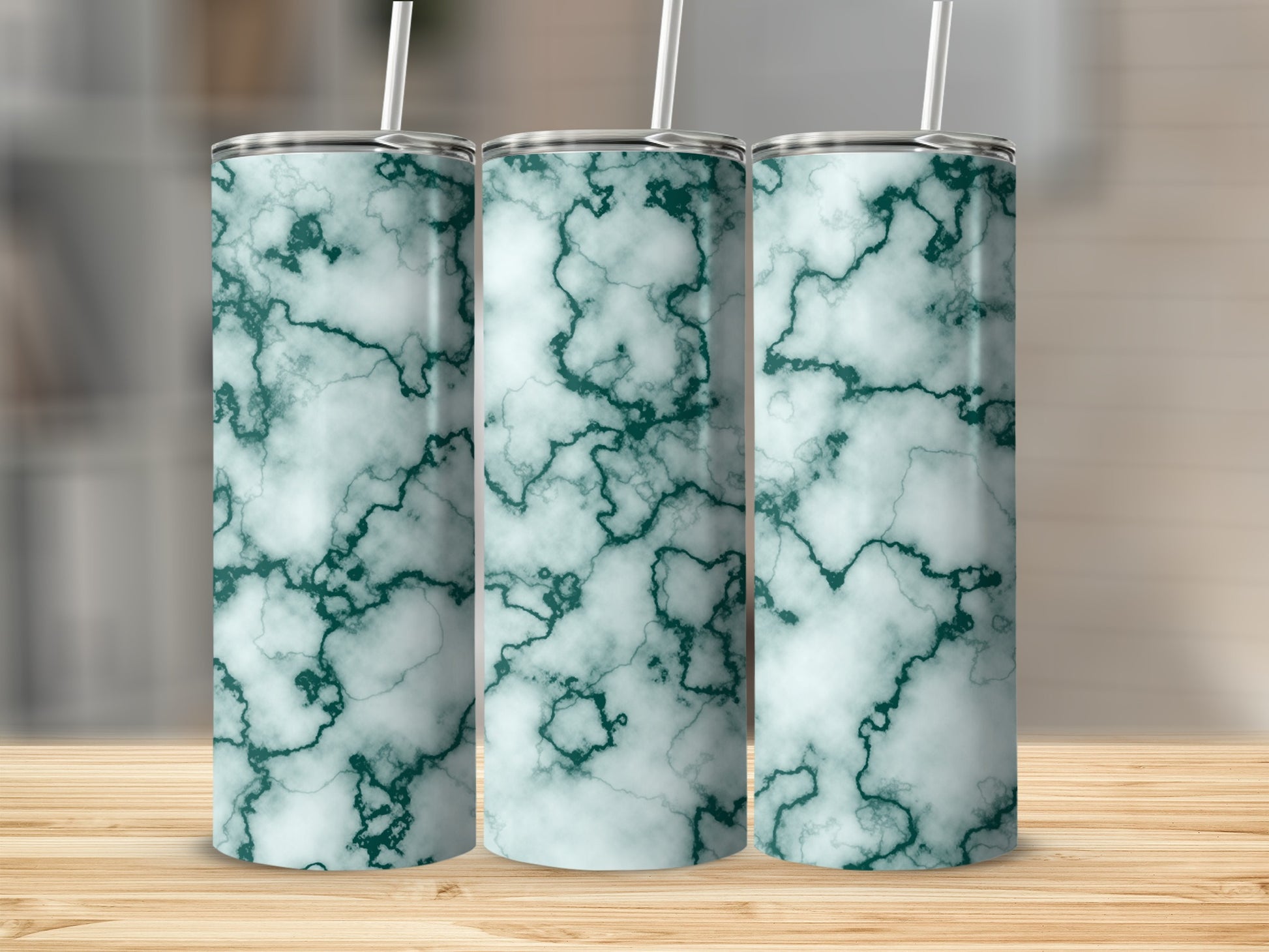 Three tumblers with a green marble pattern stand on a wooden surface.