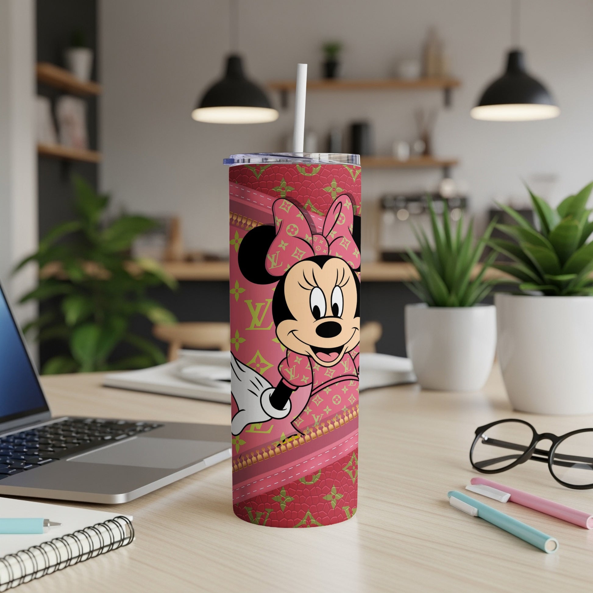 Minnie Mouse in pink designer outfit on a patterned tumbler with a straw.