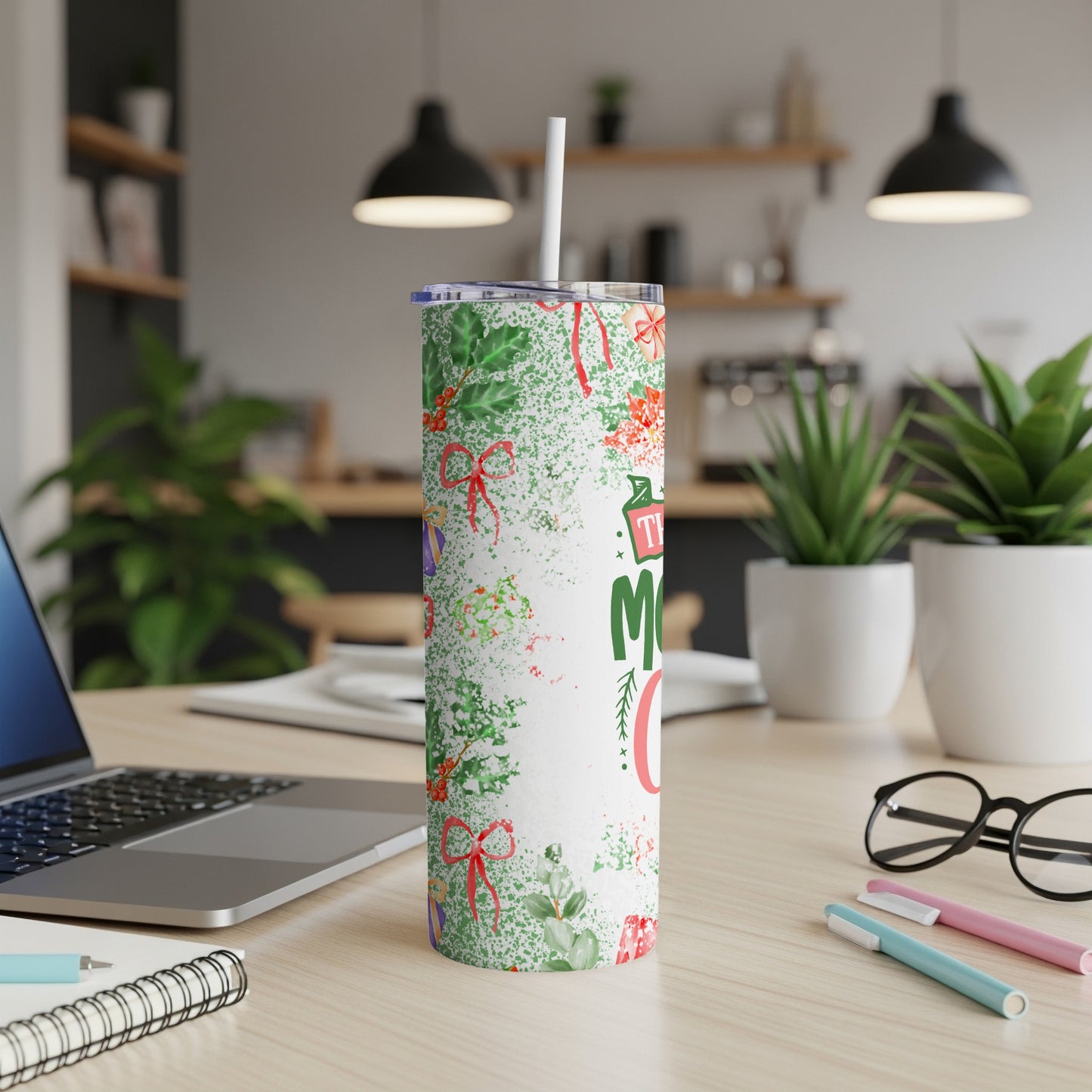 White tumbler with red and green Christmas pattern, straw, and text.