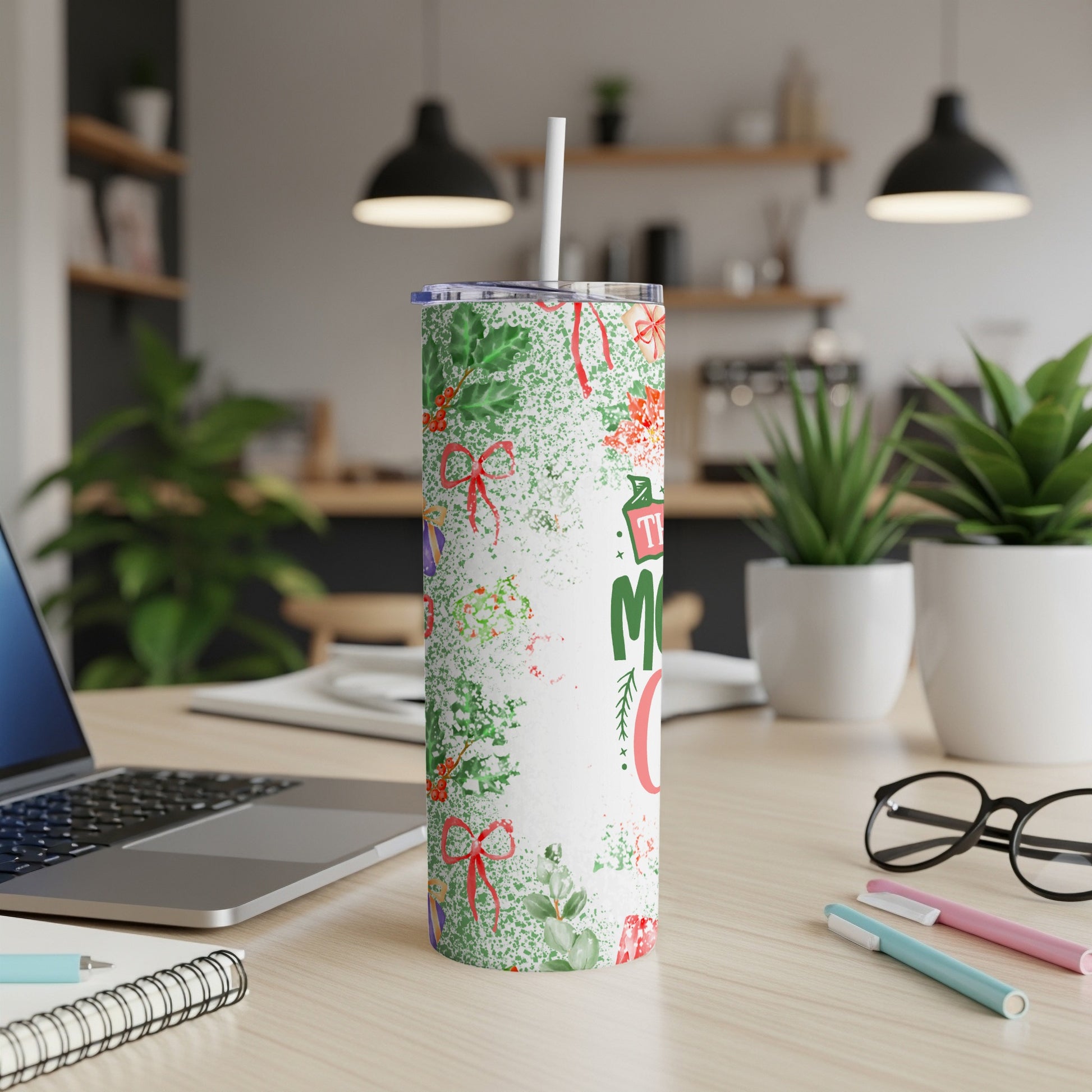 White tumbler with red and green Christmas pattern, straw, and text.