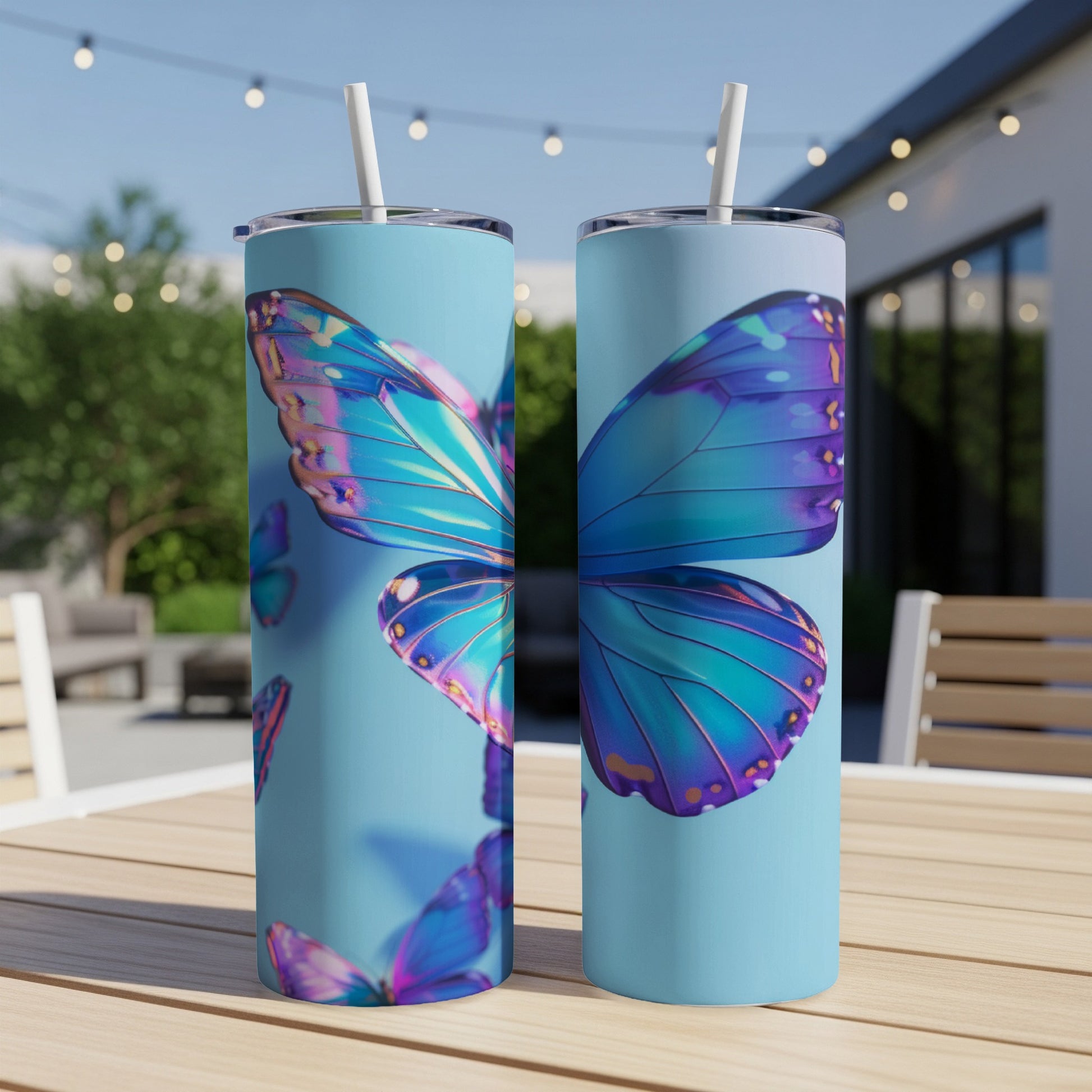 Two tall tumblers with holographic butterfly wings design on a table.