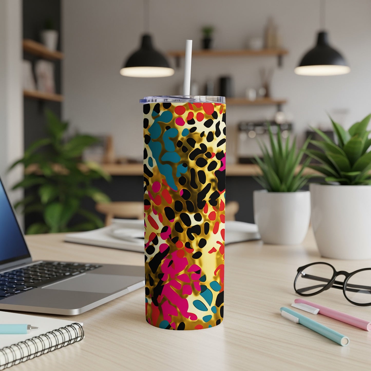Gold tumbler with colorful leopard print and a white straw.