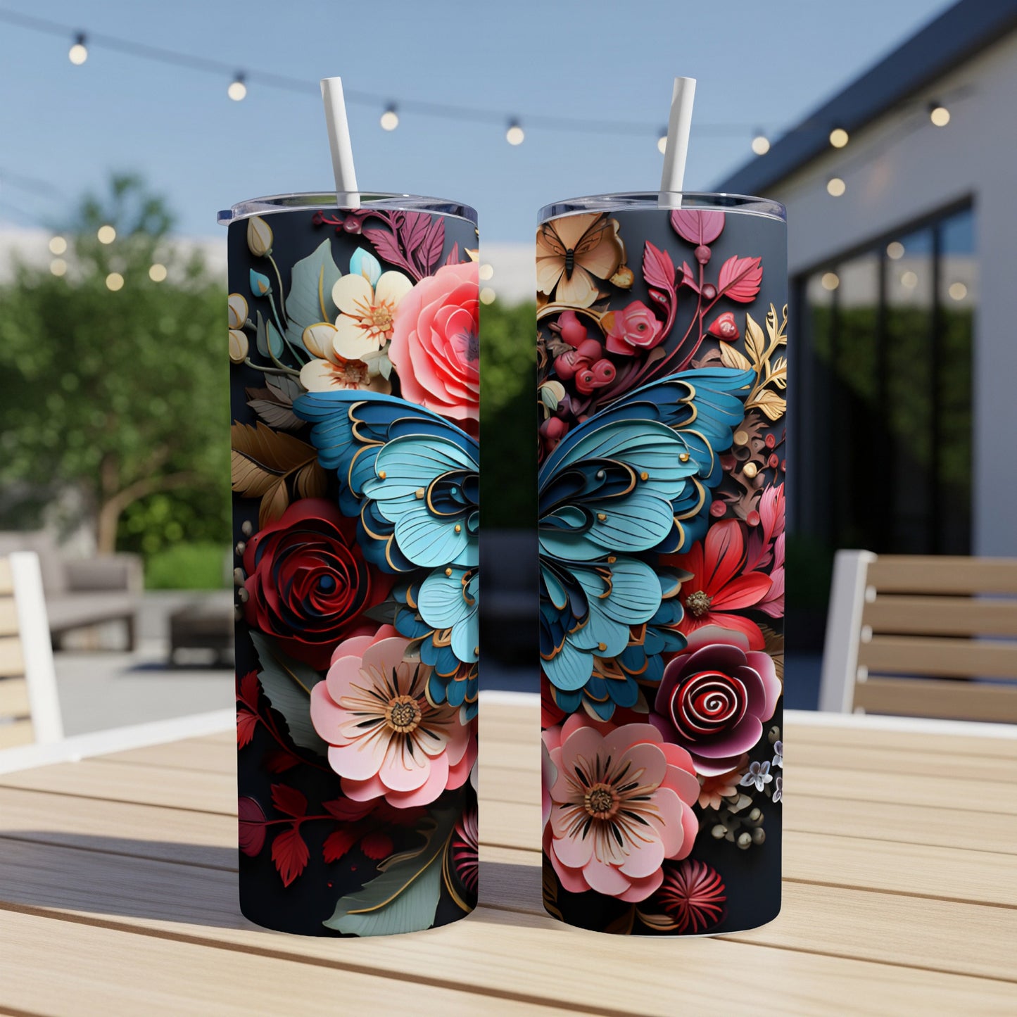 Two tall tumblers with blue butterfly and floral designs sit on a wooden table.