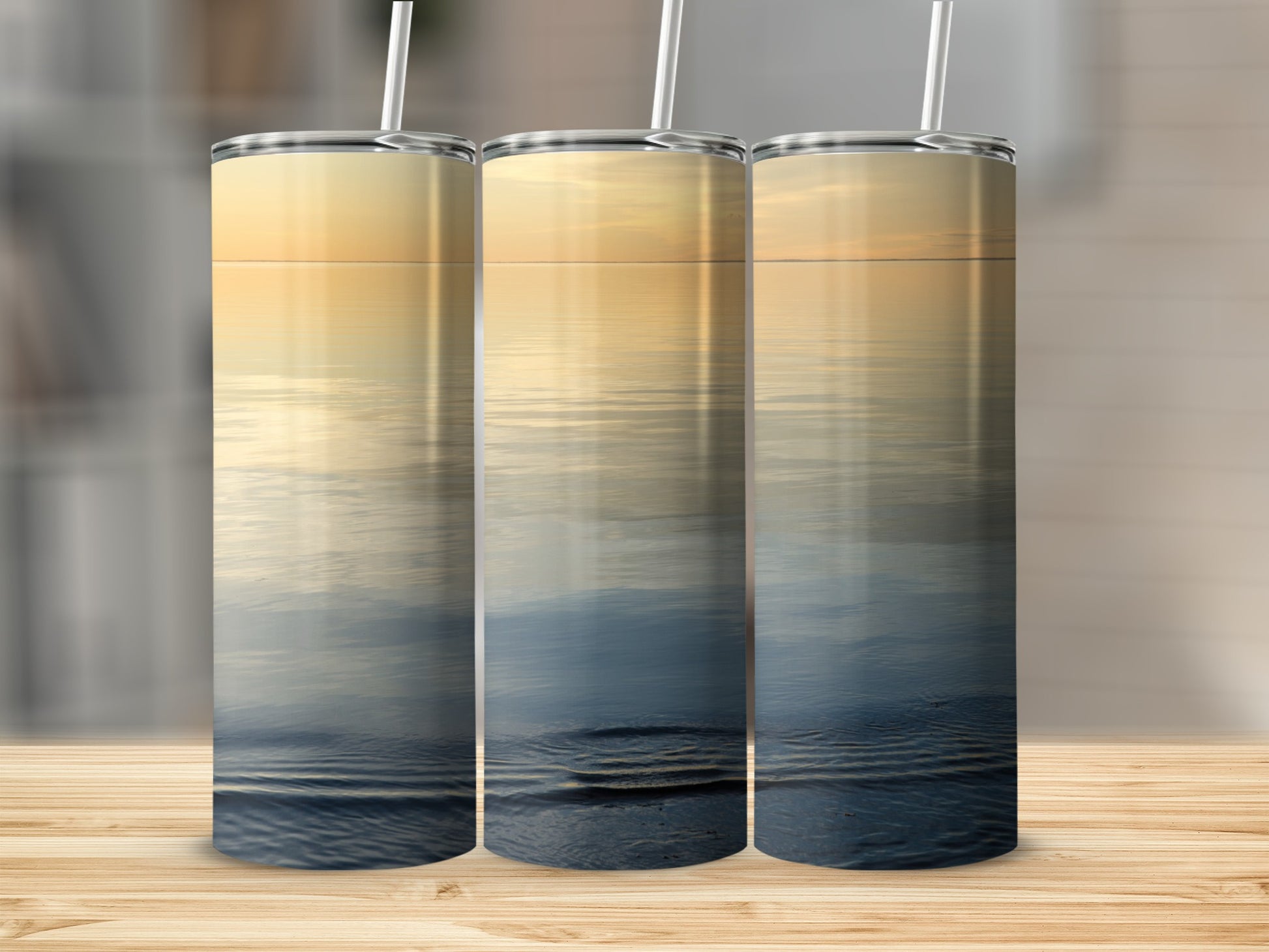 Three tall tumblers with a serene sunset over water reflection design.