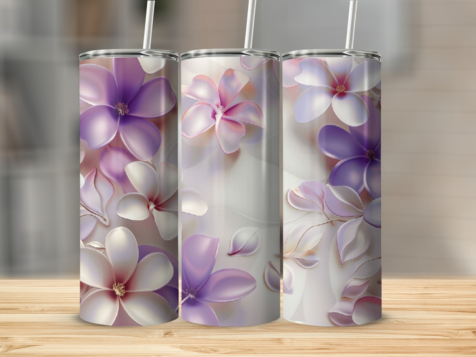 Three tumblers with delicate purple and white floral designs stand on a wooden surface.