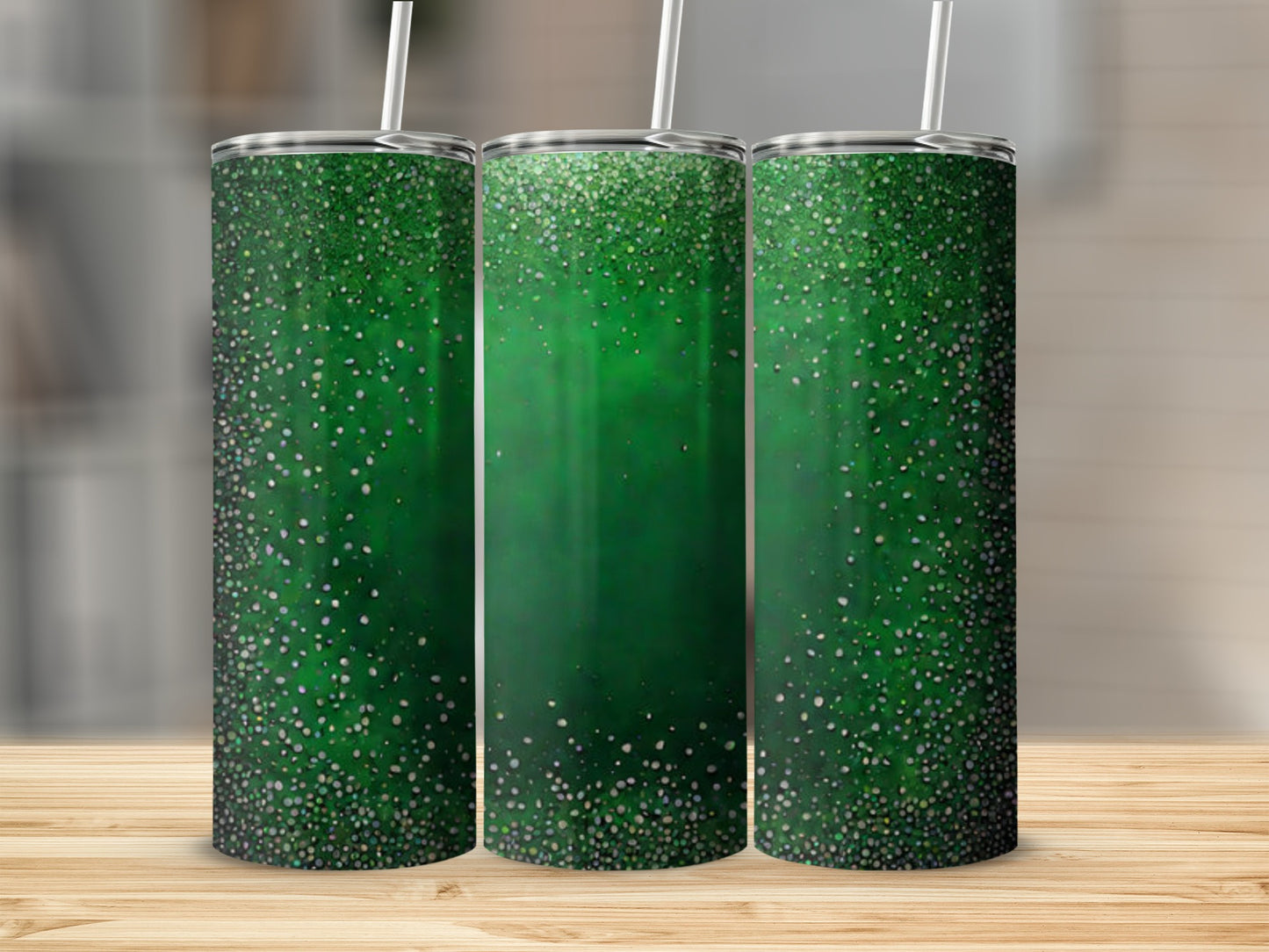 Three green tumblers with glitter gradient, displayed on a wooden surface.
