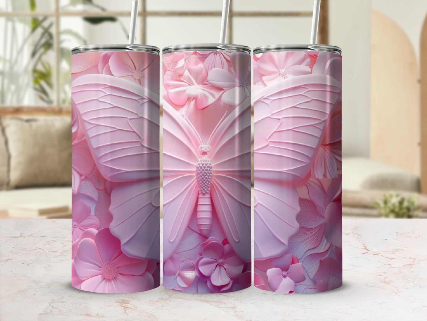 Pink butterfly and floral design on three tumblers with straws.