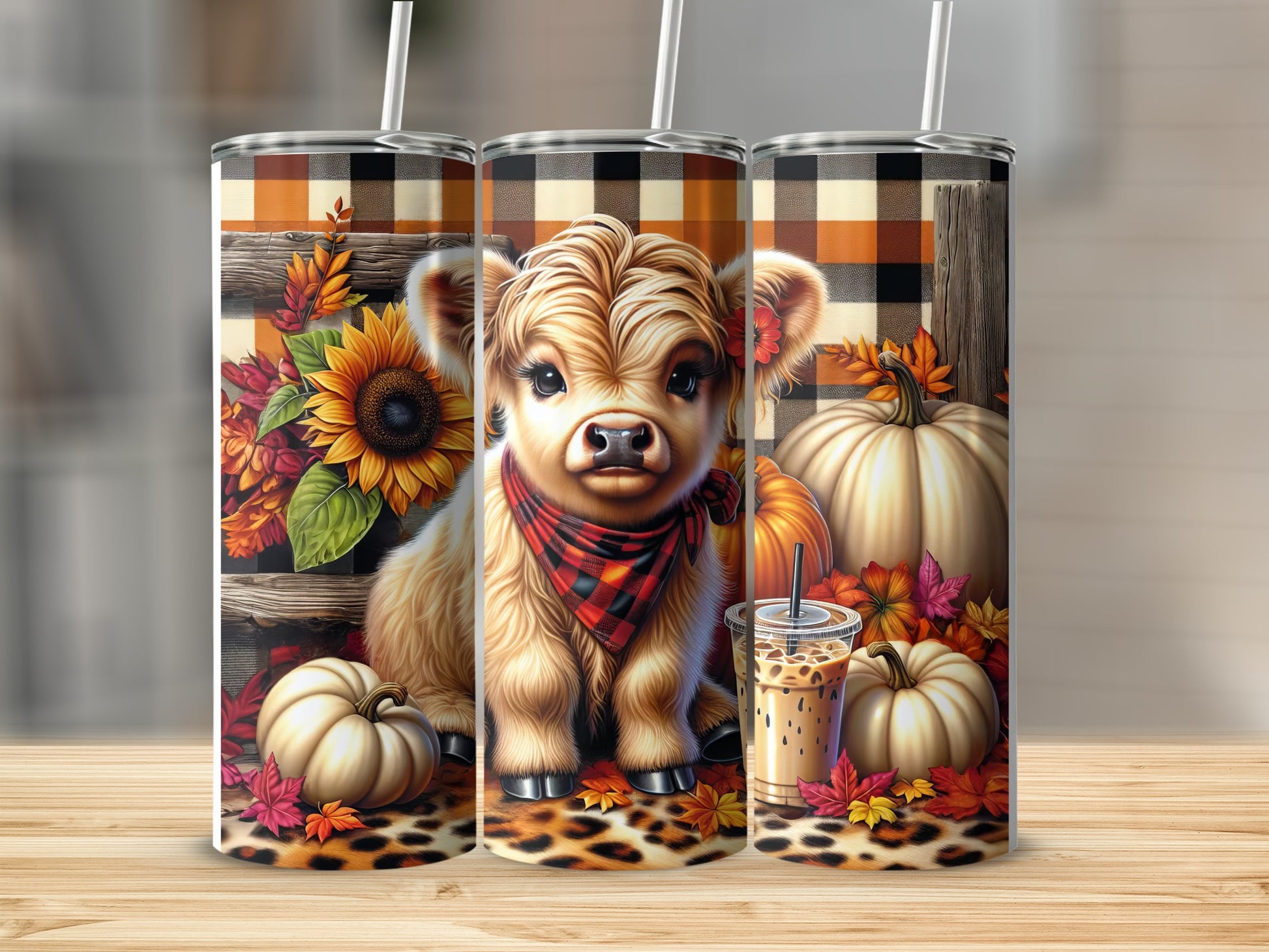 Highland cow and pumpkin design on three tumblers with fall foliage.