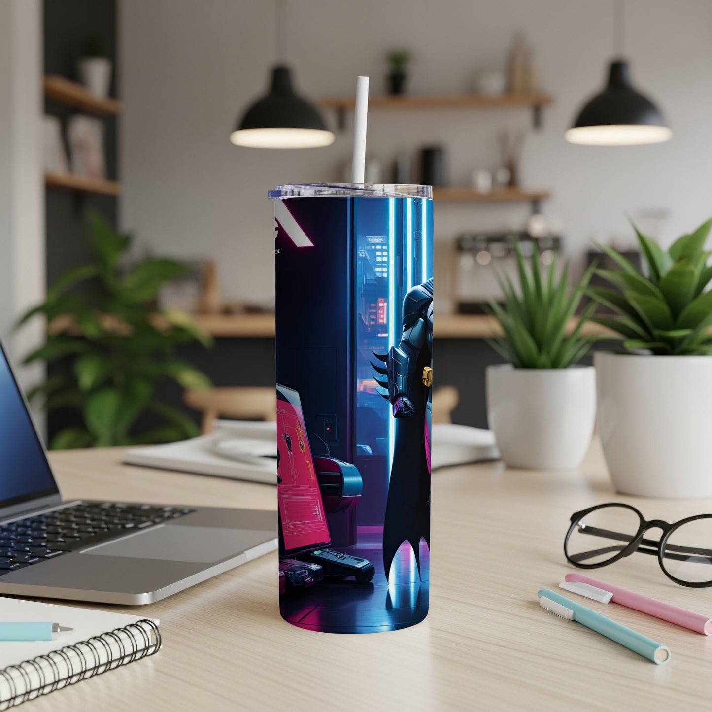 Sleek tumbler with a neon-lit Batman graphic on a desk with laptop and pens.