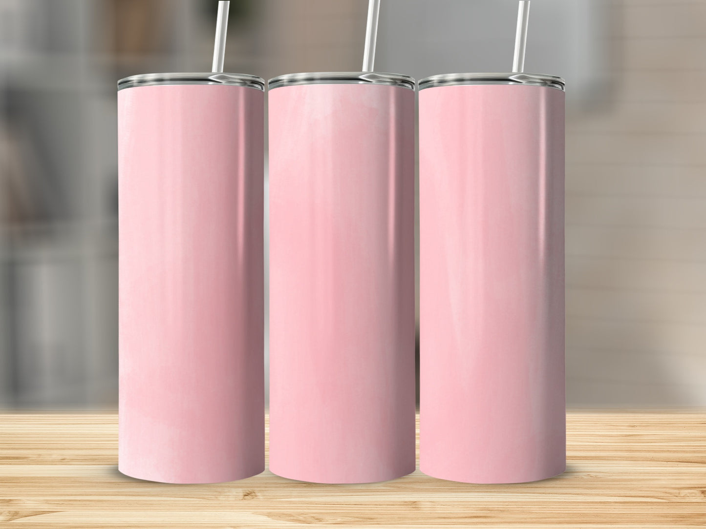 Three tall pink tumblers with white straws on a wooden surface.