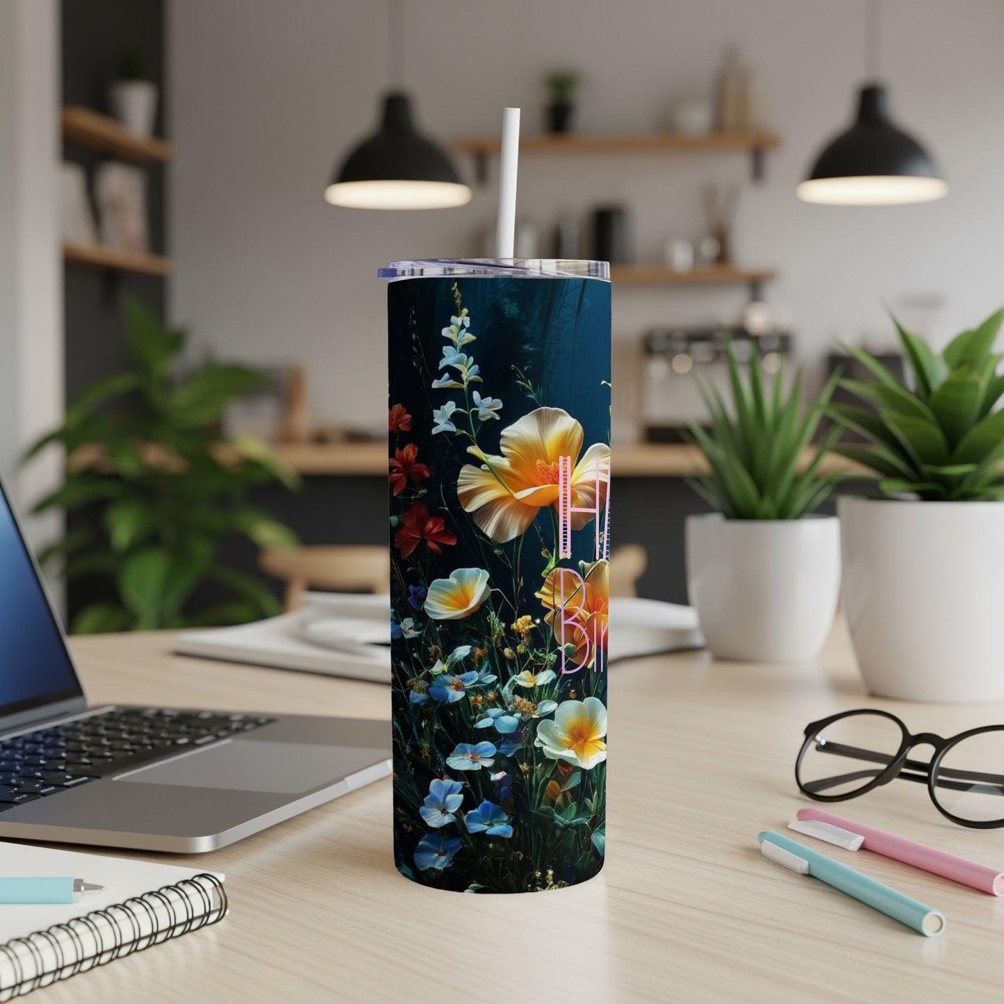Tumbler with colorful floral pattern and white straw on a desk.