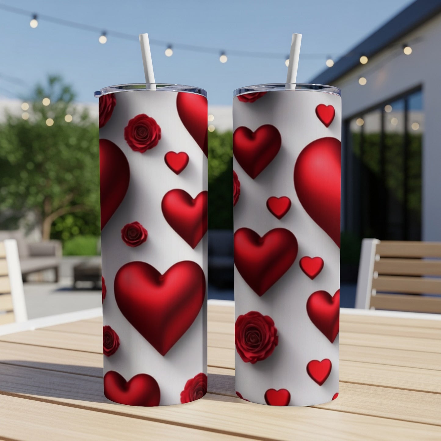 Two tumblers with red hearts and roses pattern on a table.