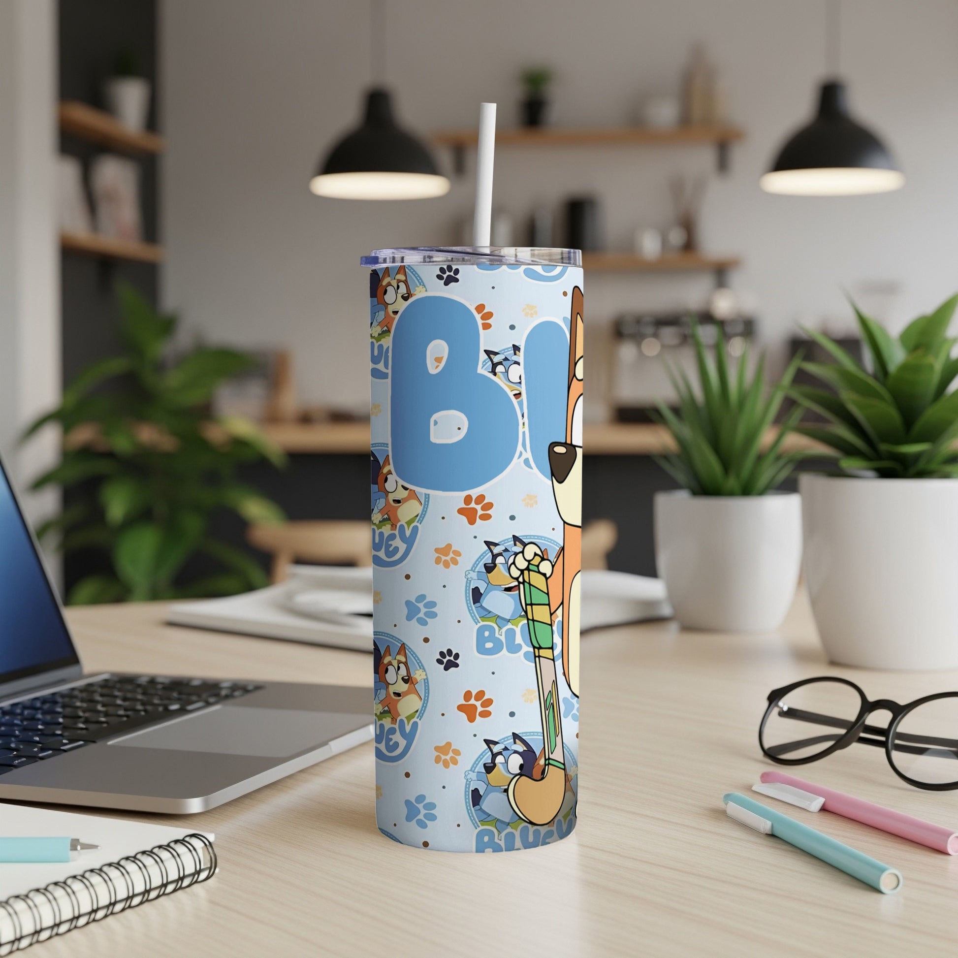 Bluey character tumbler with straw on desk.