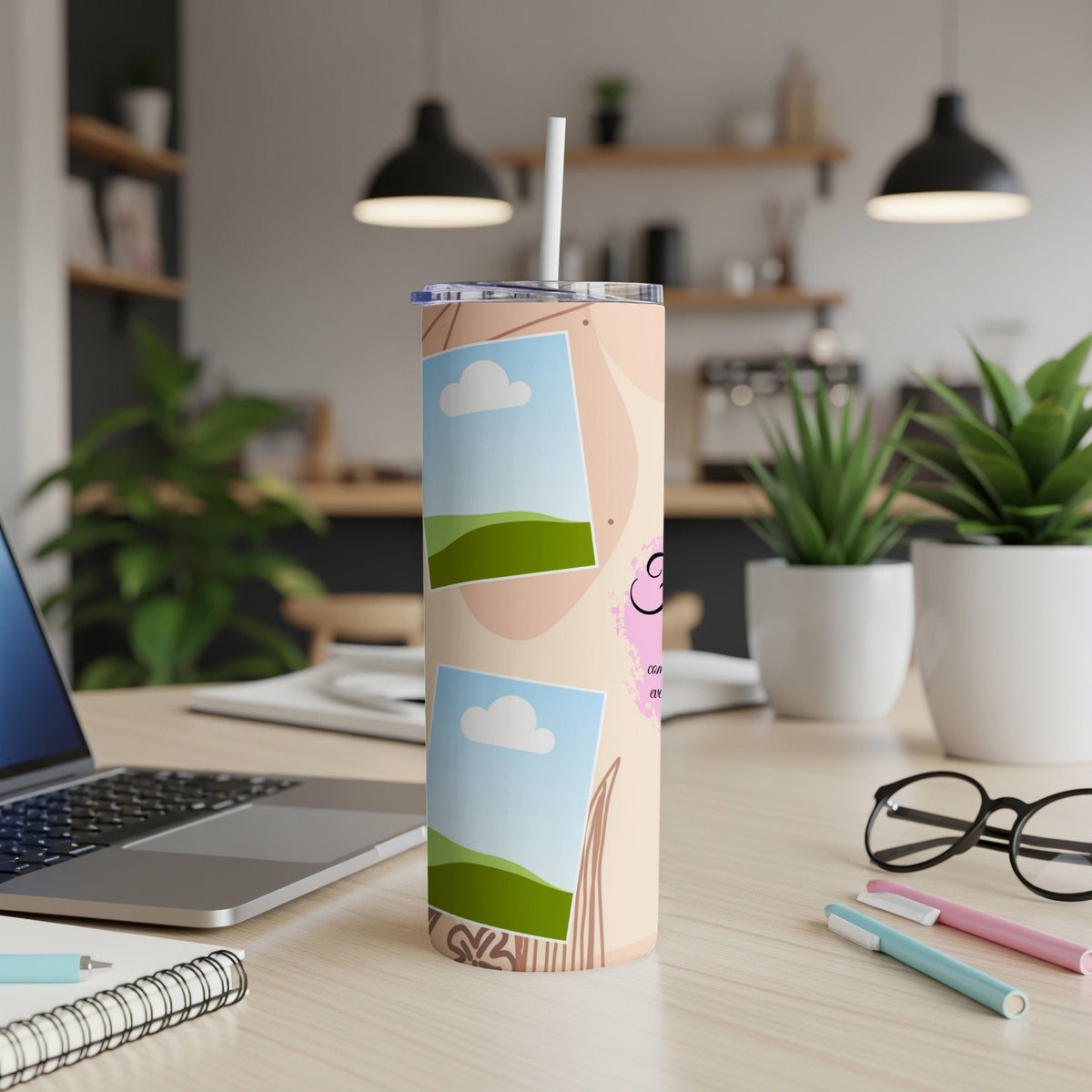 Beige tumbler with two framed landscape photos and pink graphic.