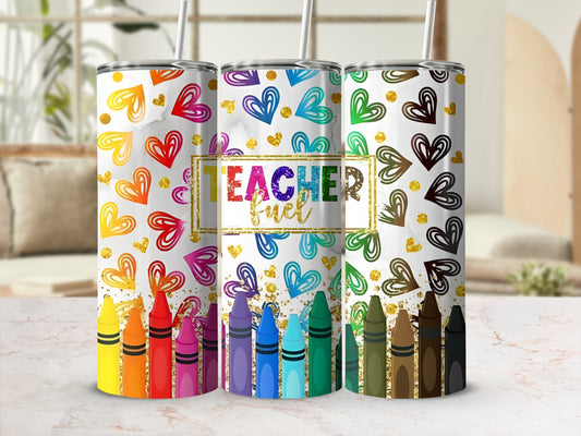Three tumblers with colorful hearts and crayons, one saying "Teacher Fuel".