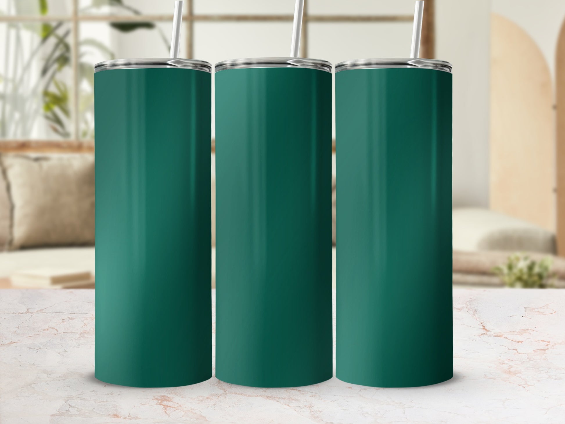 Three teal tumblers with straws stand on a marble surface.