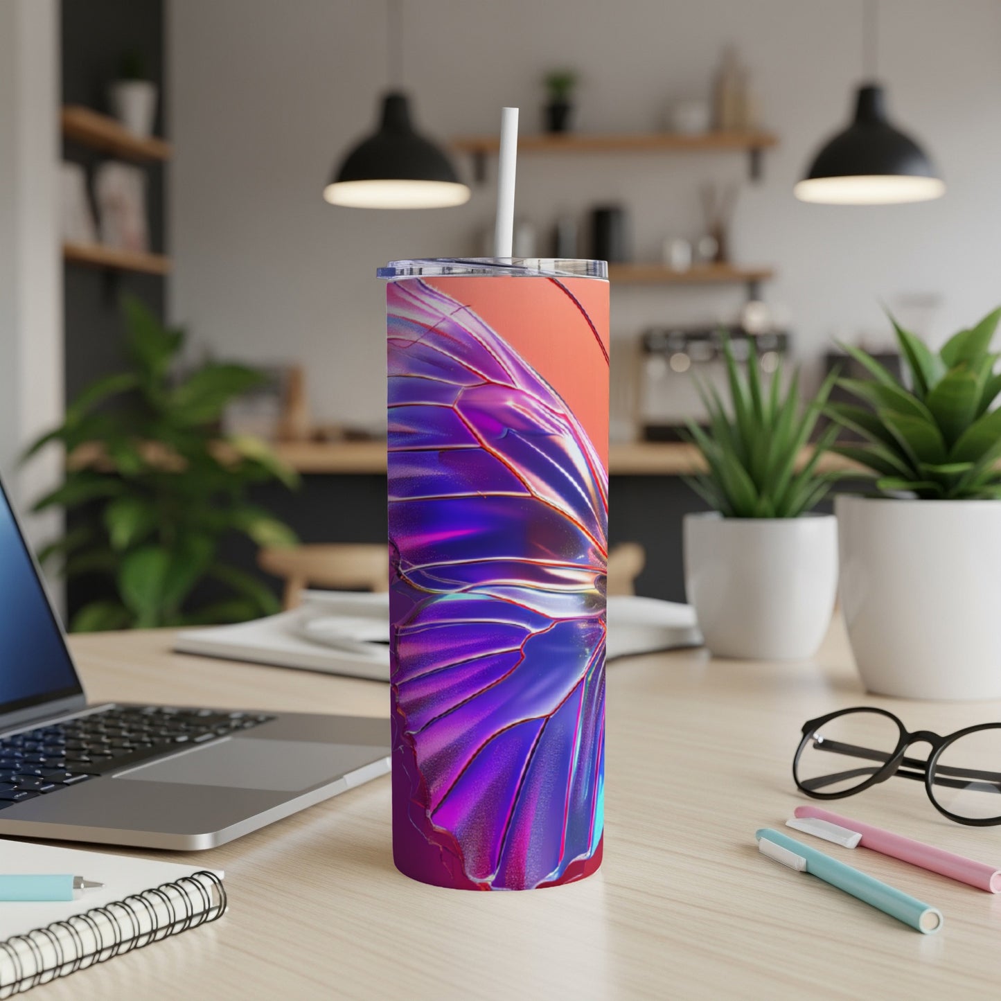 Tumbler with a iridescent butterfly wing design on a desk.