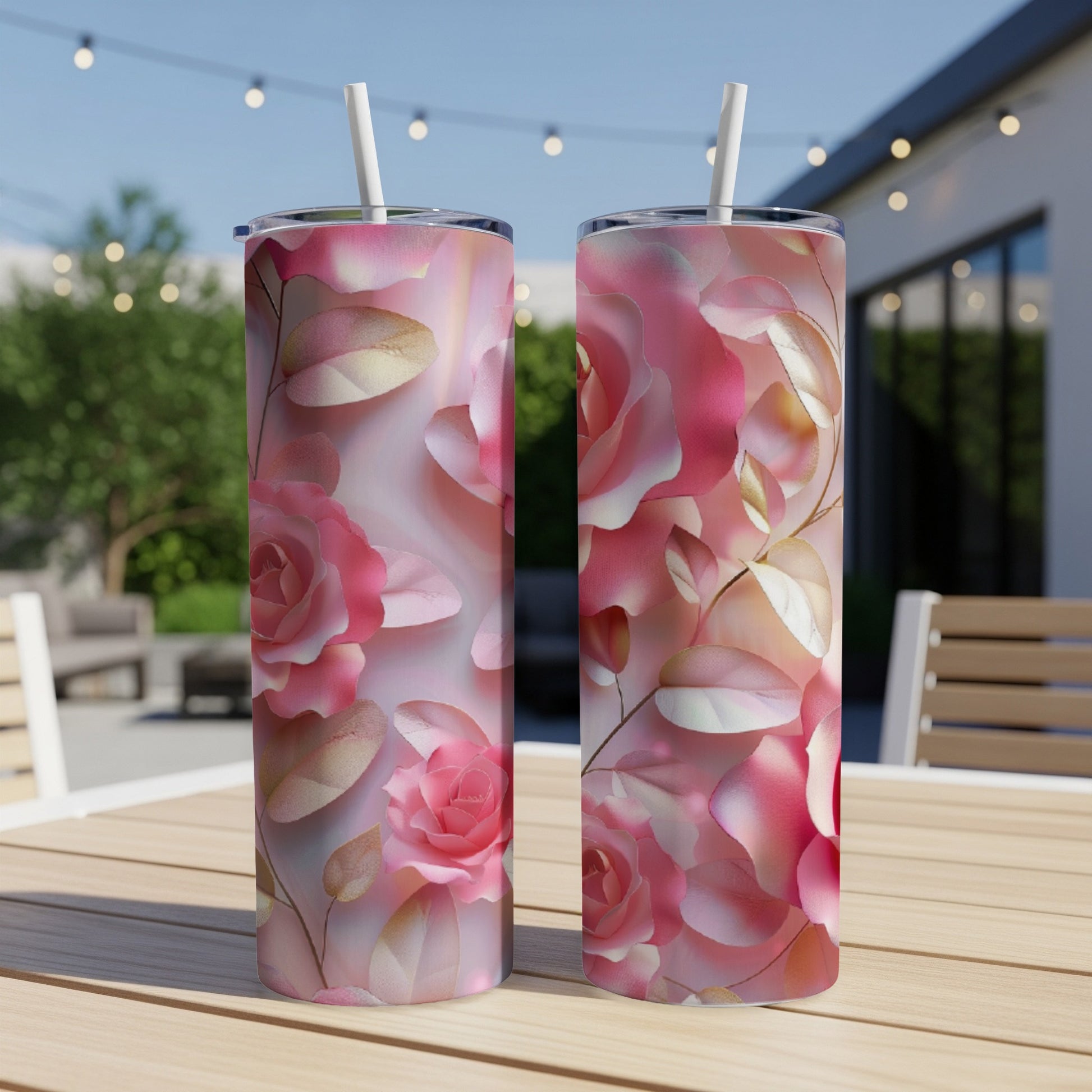 Two tall tumblers with pink rose floral design and white straws.