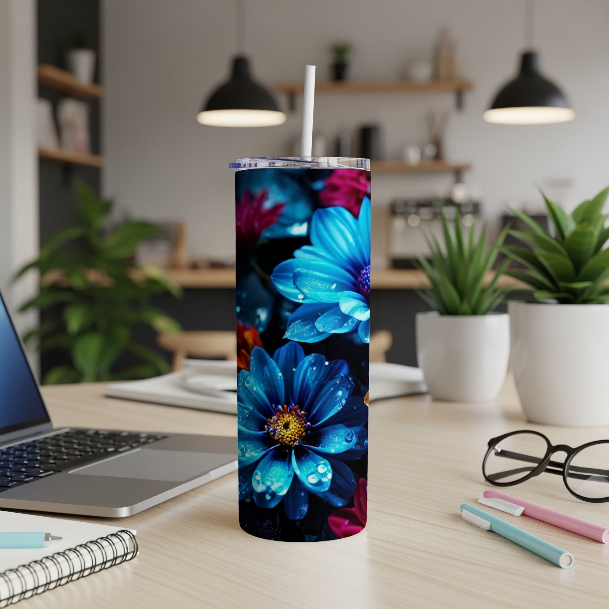 Tumbler with vibrant blue and pink floral pattern, on a desk.