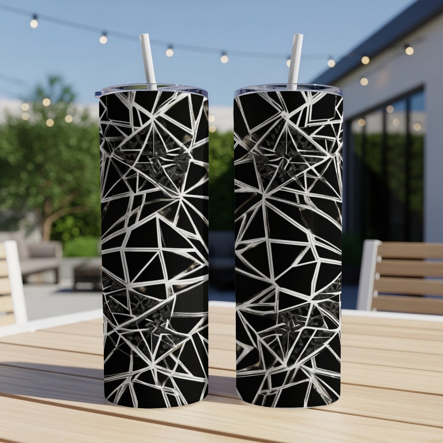 Two black tumblers with a white geometric web design and straws.