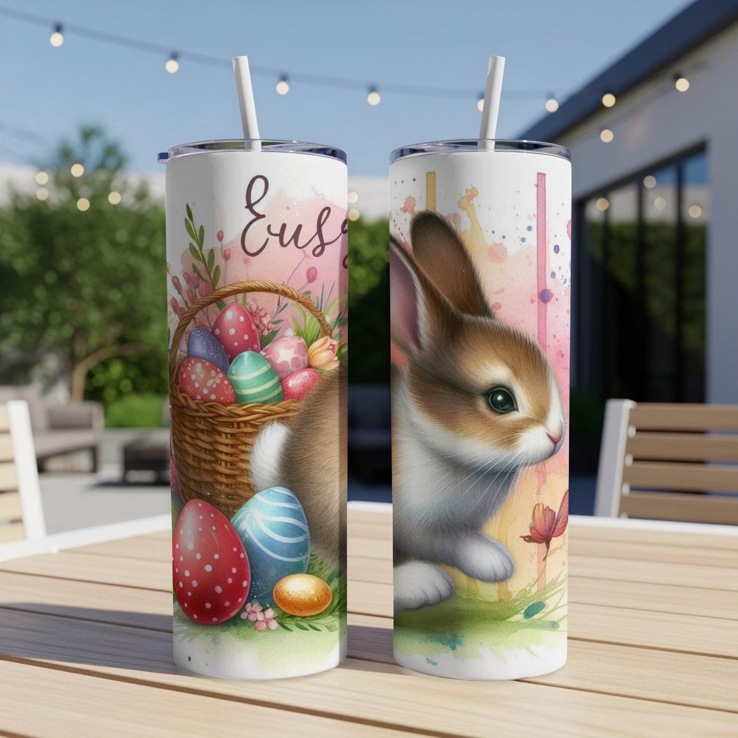 Two Easter-themed tumblers with bunnies and decorated eggs on a table.